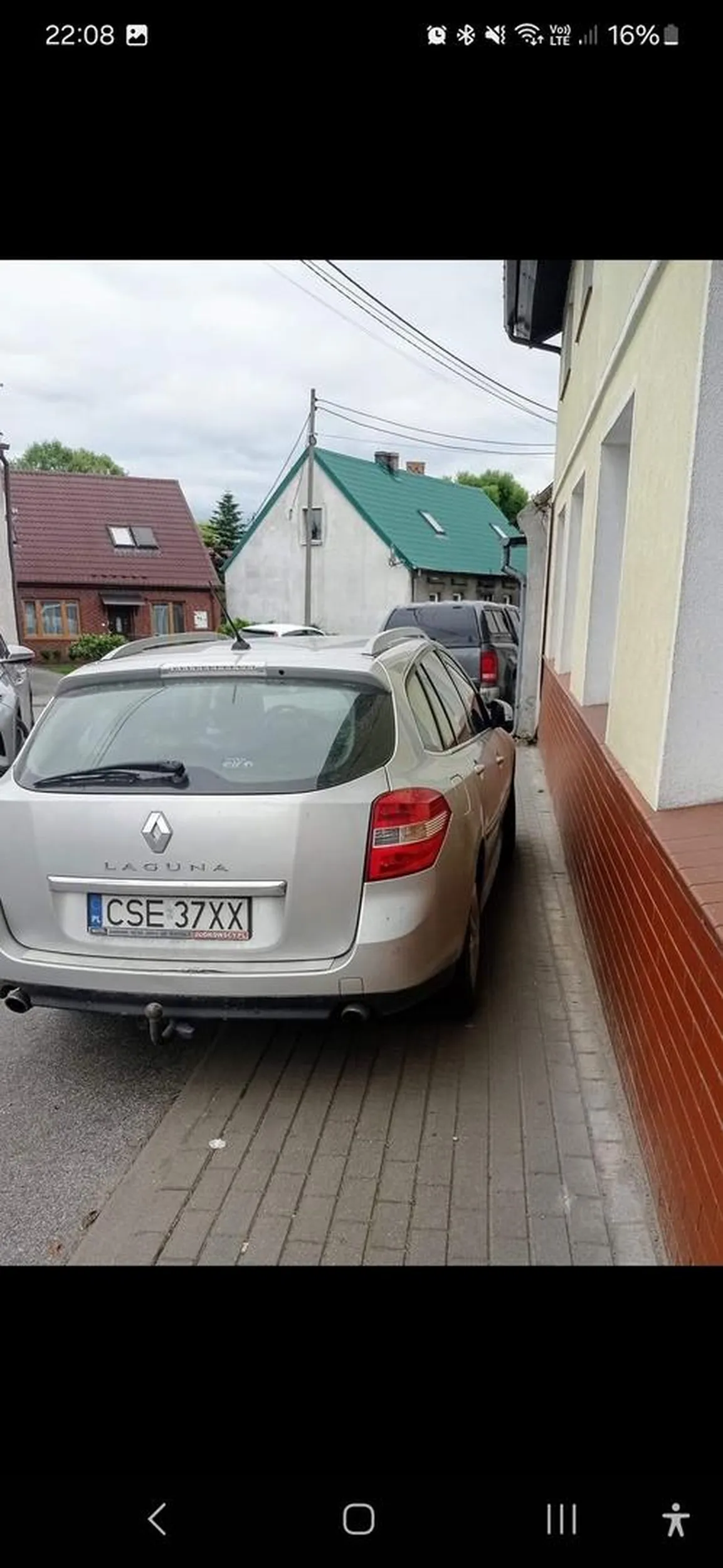 Pajac stoi na chodniku na całej szerokości