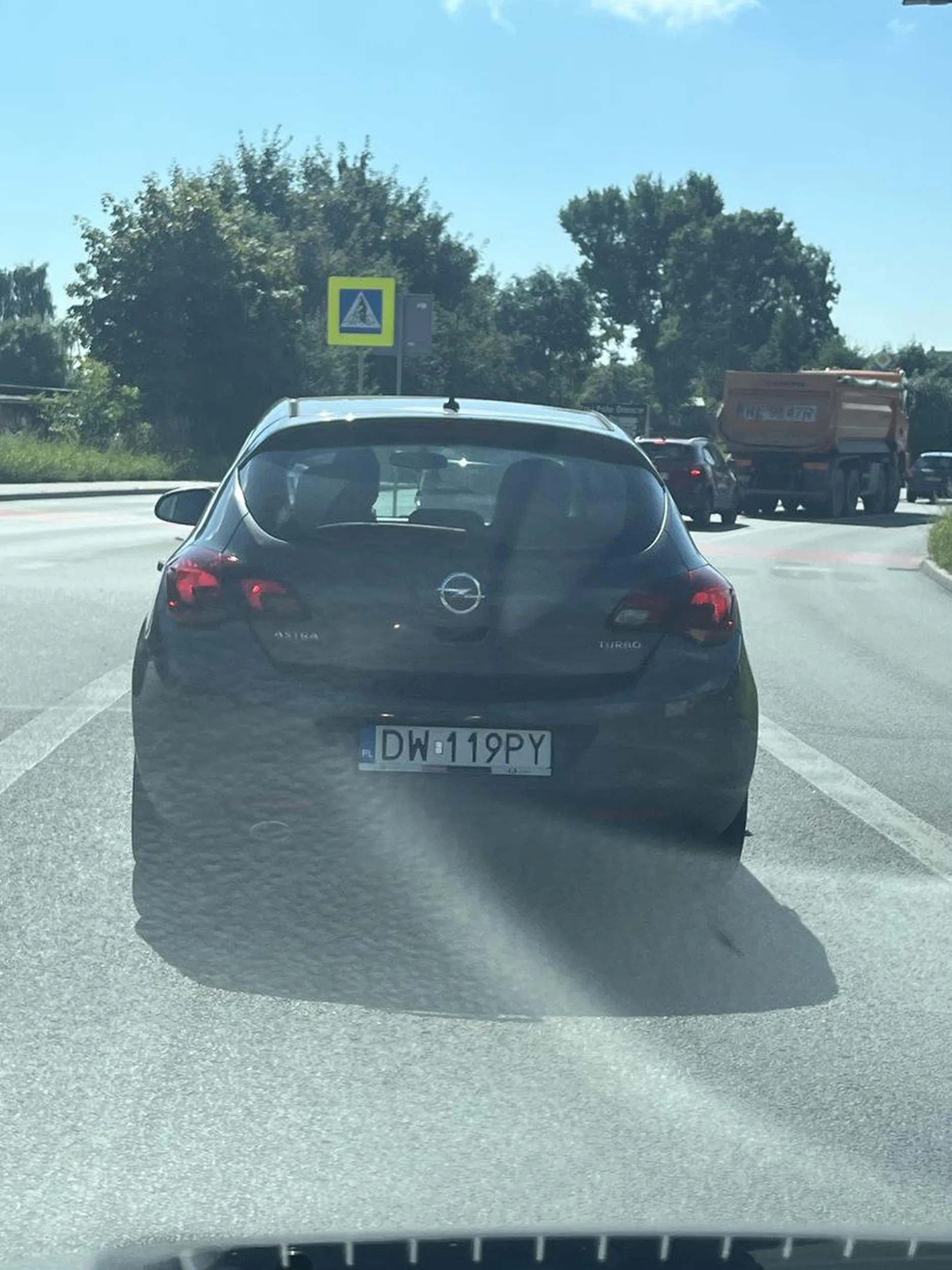 Facet bawi sie telefonem i stoi przed pustym przejsciem. Gdy ci co za nim stoją zaczynają trąbić, ten zamiast ruszać pokazuje środkowym palcem ile zmiesci w ustach. Nastepnie ruszani gwaltownie hamuje. A potem ucieka Buspasem. Taki to pajacyk.