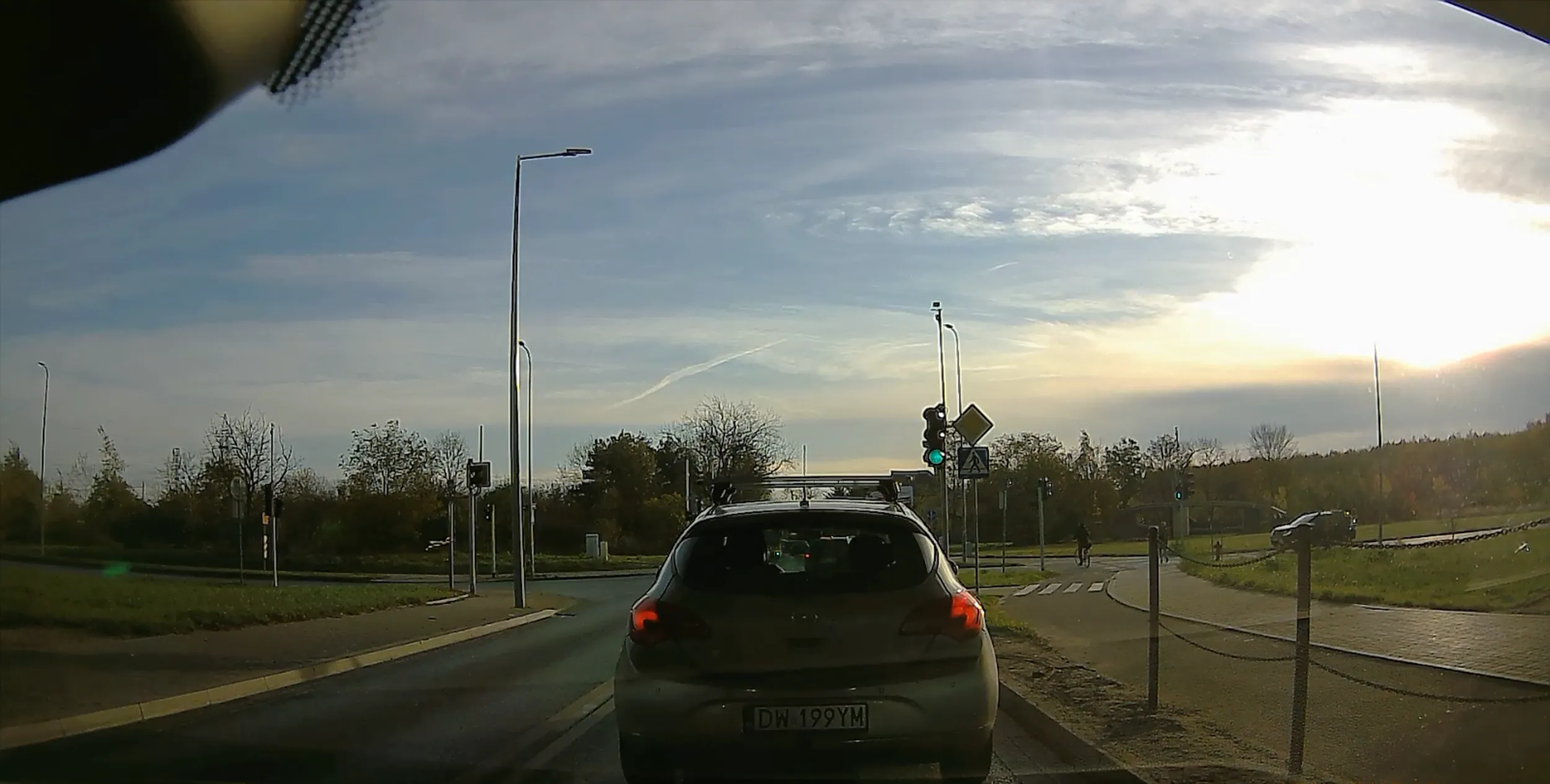 Czyta telefon na swiatlach i stoi na zielonym.