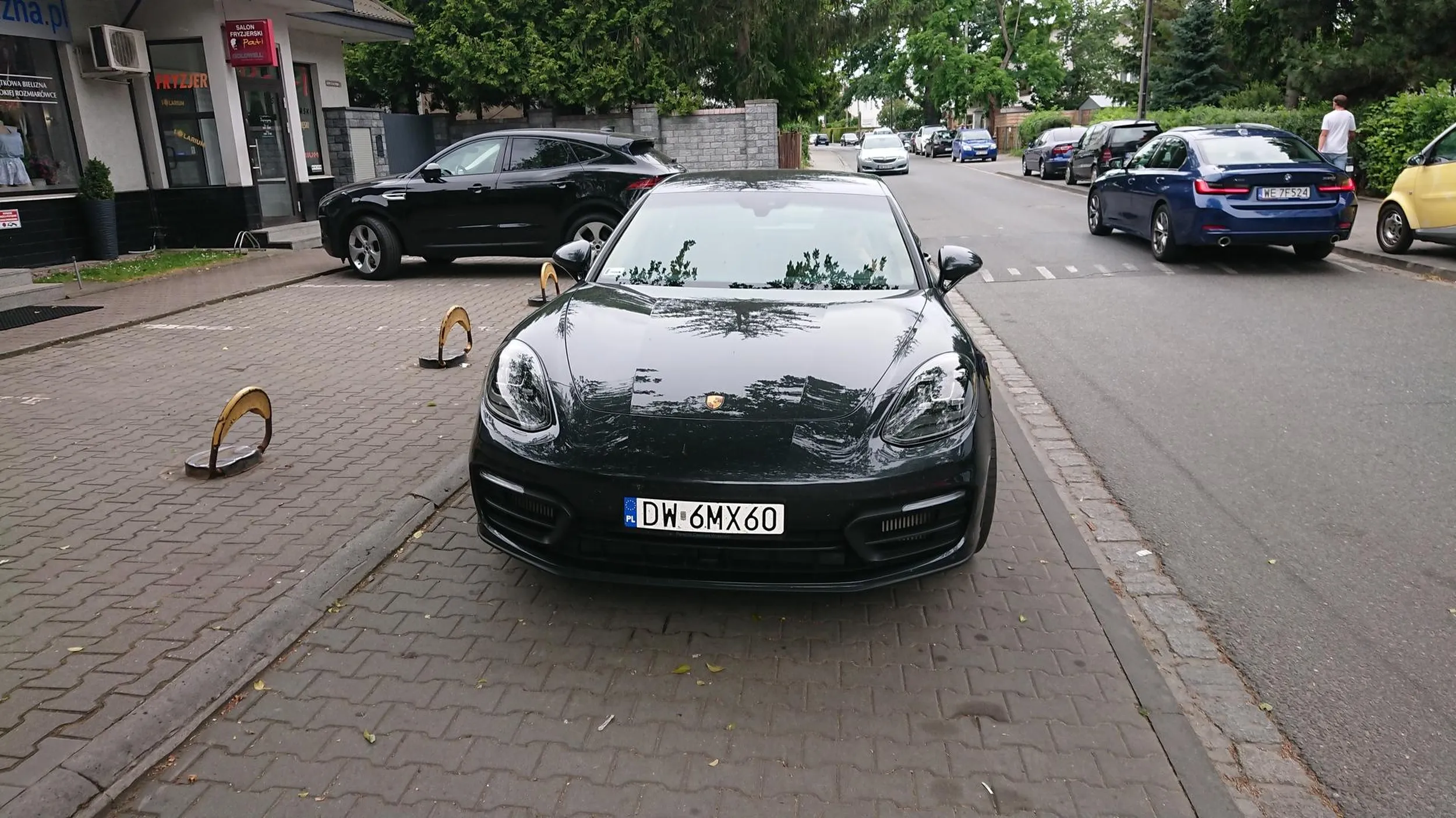 Pan z Porsche uważa, że zrobienie zdjęcia jego bolidu blokującego cały chodni to przejaw braku współżycia społecznego. Do tego nie zauważył, że ćwierć wieku temu zmieniły się przepisy i zakaz zatrzymywania dotyczy także chodnika - wg kierującego zakaz dotyczy tylko jezdni. Pozdrawiam kierowcę i sądzę, że skoro stać go na Porsche to na kurs prawa jazdy również.