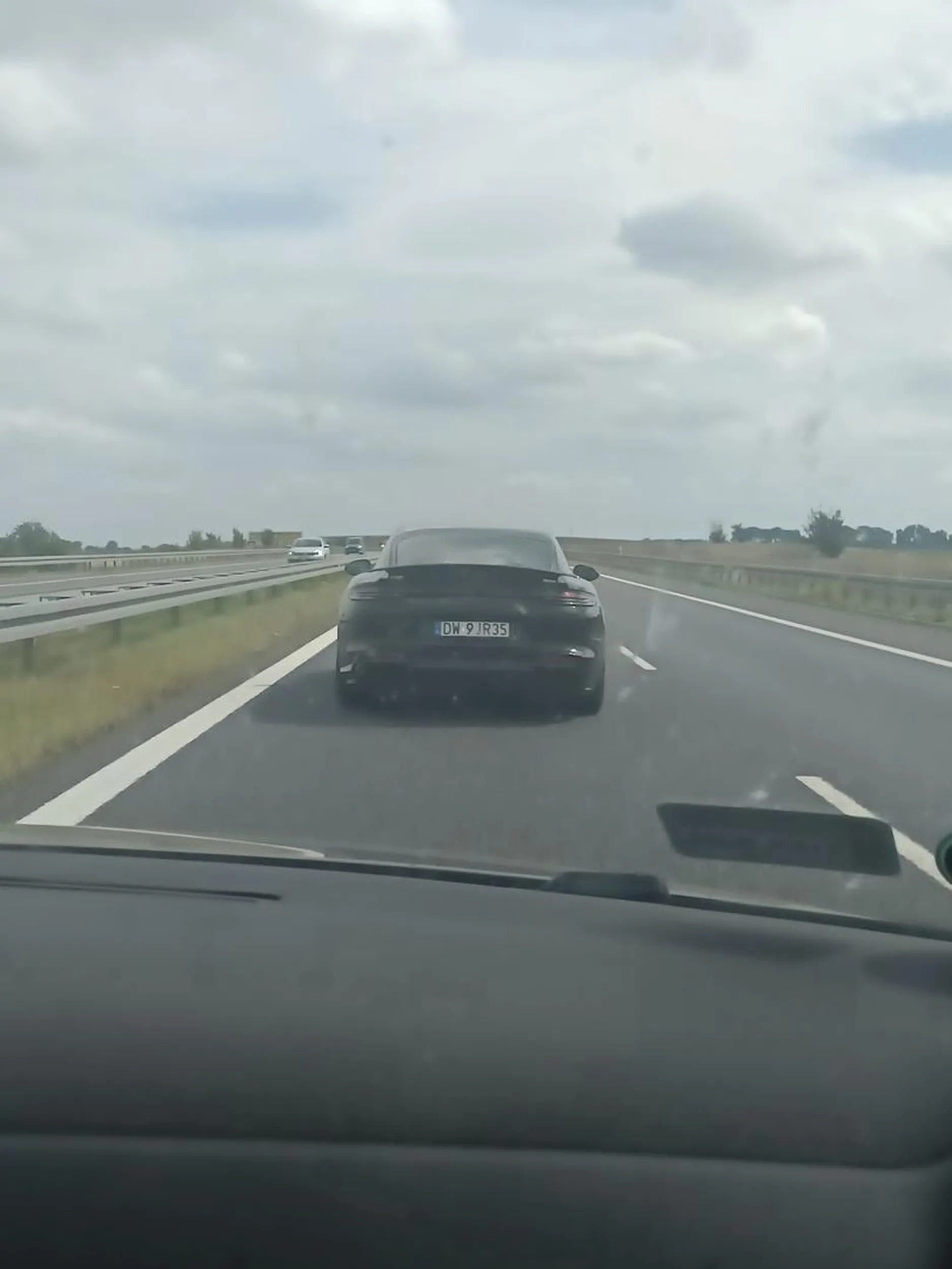 Jedzie lewym pasem, nie zwraca uwagi na innych. Telefon w ręce.