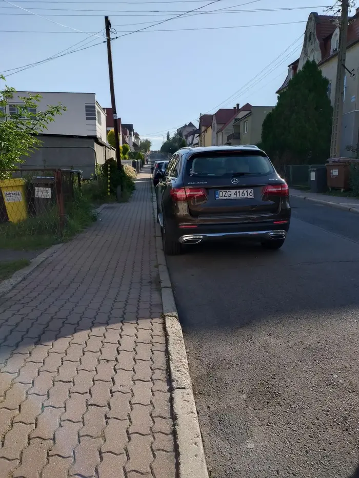 Zastawia bramę wyjazdową i dyskutuje, że tylko po chleb idzie. Co ciekawe miejsce było wolne przed bramą