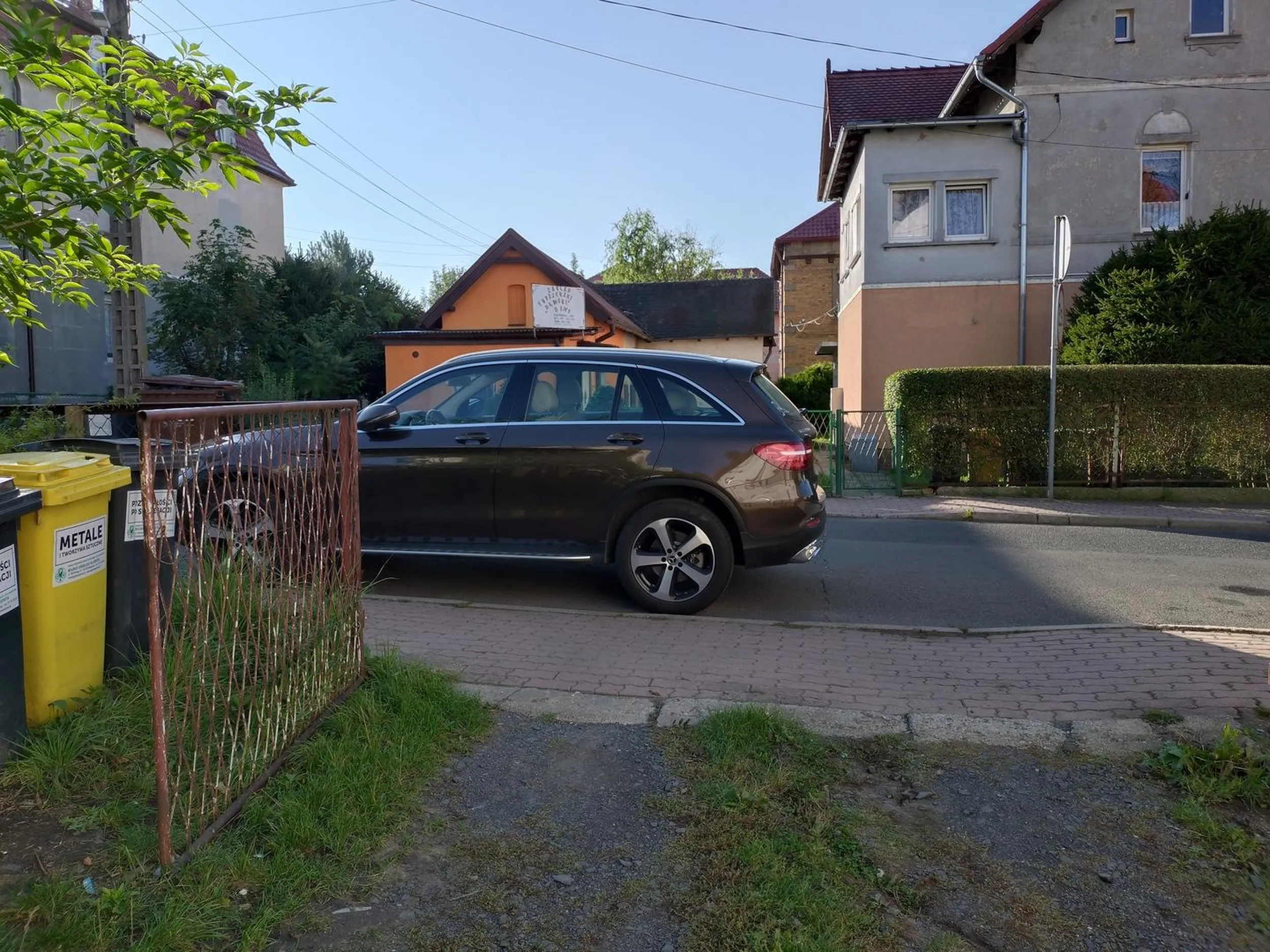 Zastawia bramę wyjazdową i dyskutuje, że tylko po chleb idzie. Co ciekawe miejsce było wolne przed bramą