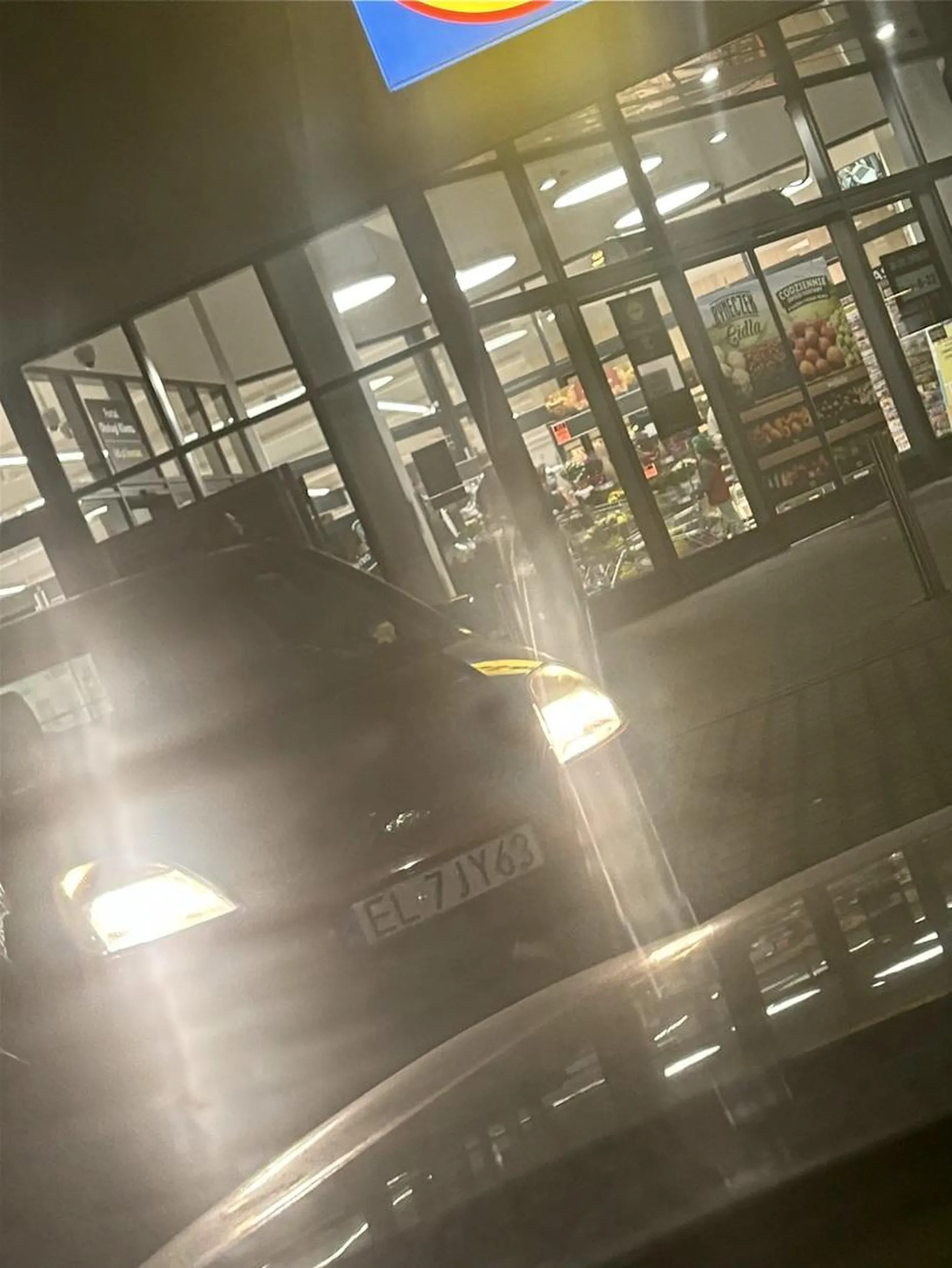 Kretyn otwiera drzwi uderzając w samochód zaparkowany obok. Zupełnie się tym nie przejmując, wsiada szybko do auta i odjeżdża.