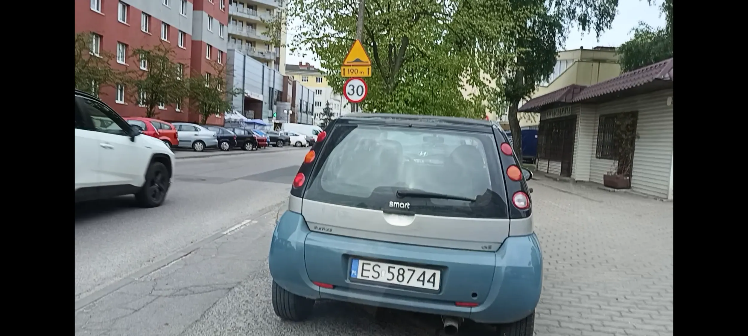 Durak z łódzkiego porzucił wraka w Warszawie i stoi pół auta na chodniku a pół na jezdni i to na skrzyżowaniu gdzie utrudnia widoczność na ulicę z prawej strony. Taki mam widok i strach wyjechać stąd.