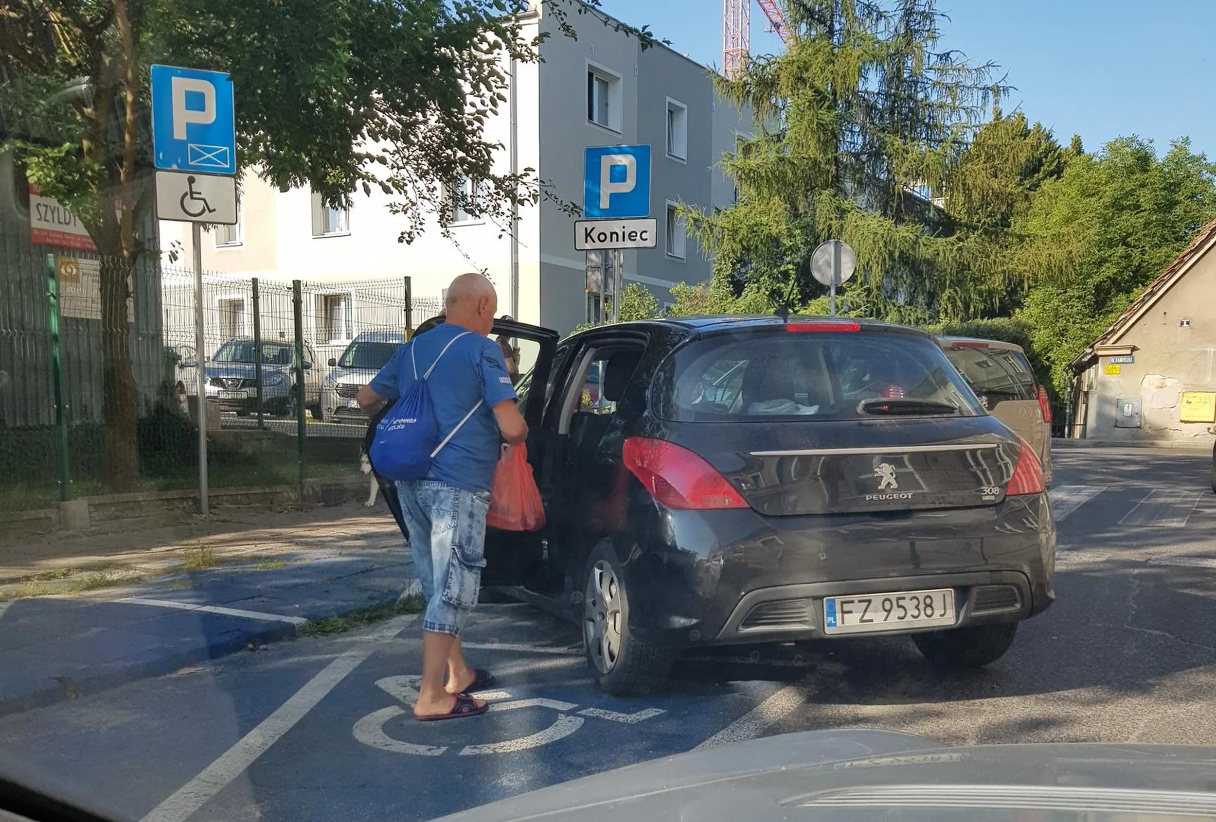 Zaparkował na środku drogi blokując przejazd oraz częściowo miejsce dla niepełnosprawnych. A może właśnie dlatego ono mu się należy? Z głową nie najlepiej...