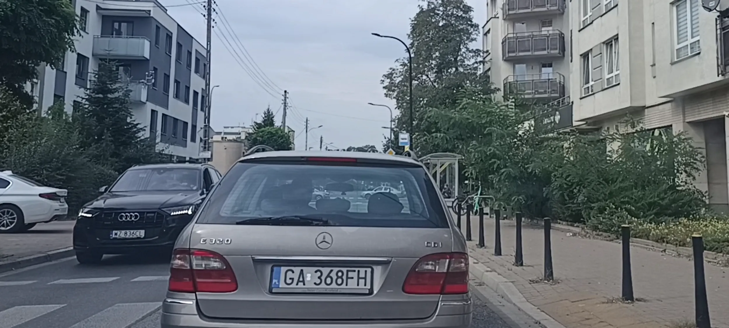 Głupek tamuje ruch i próbuje zaparkować przy jezdni gdzie nie ma żadnego miejsca parkingowego.