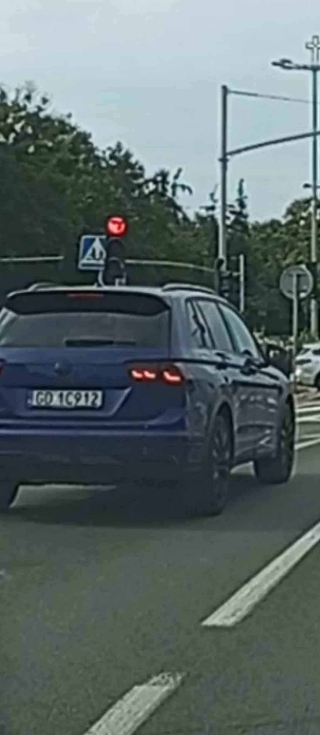 Pajac ślimaczy się lewym pasem z głową spuszczoną nad telefonem