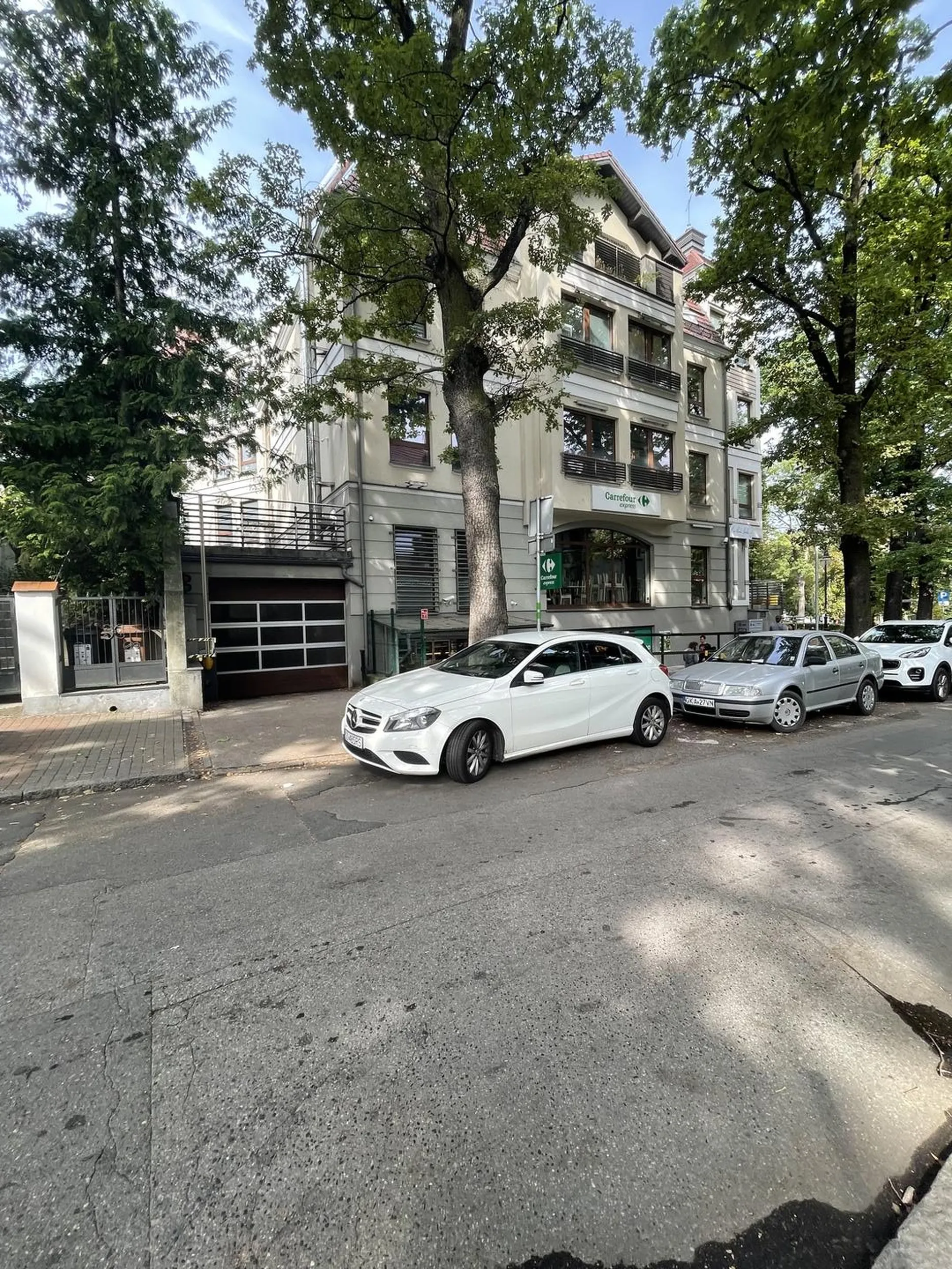 Parkowanie za znakiem "koniec parkingu" oraz zastawiony wjazd do garażu na ul. Wrońskiego w Gdańsku.