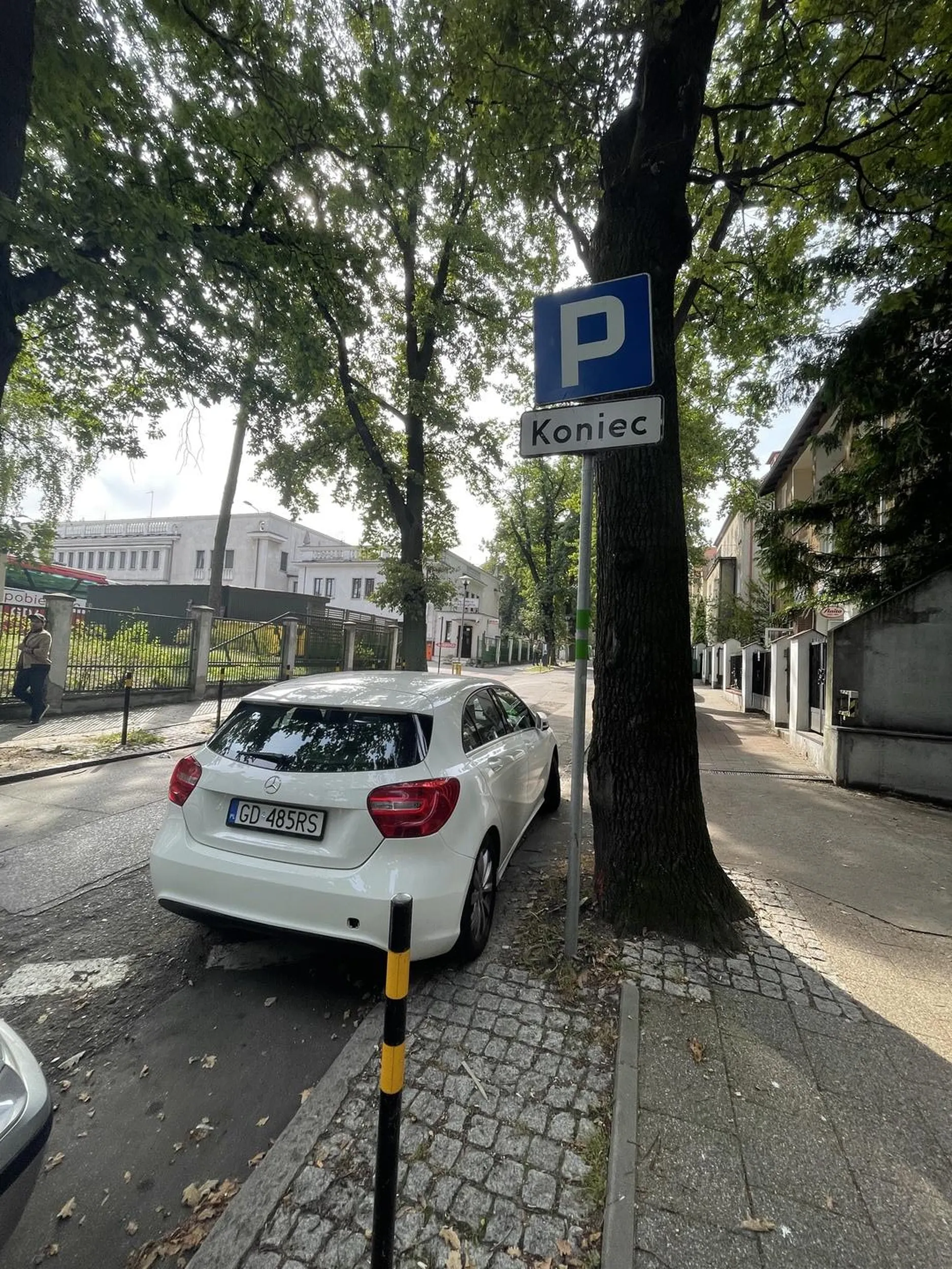 Parkowanie za znakiem "koniec parkingu" oraz zastawiony wjazd do garażu na ul. Wrońskiego w Gdańsku.