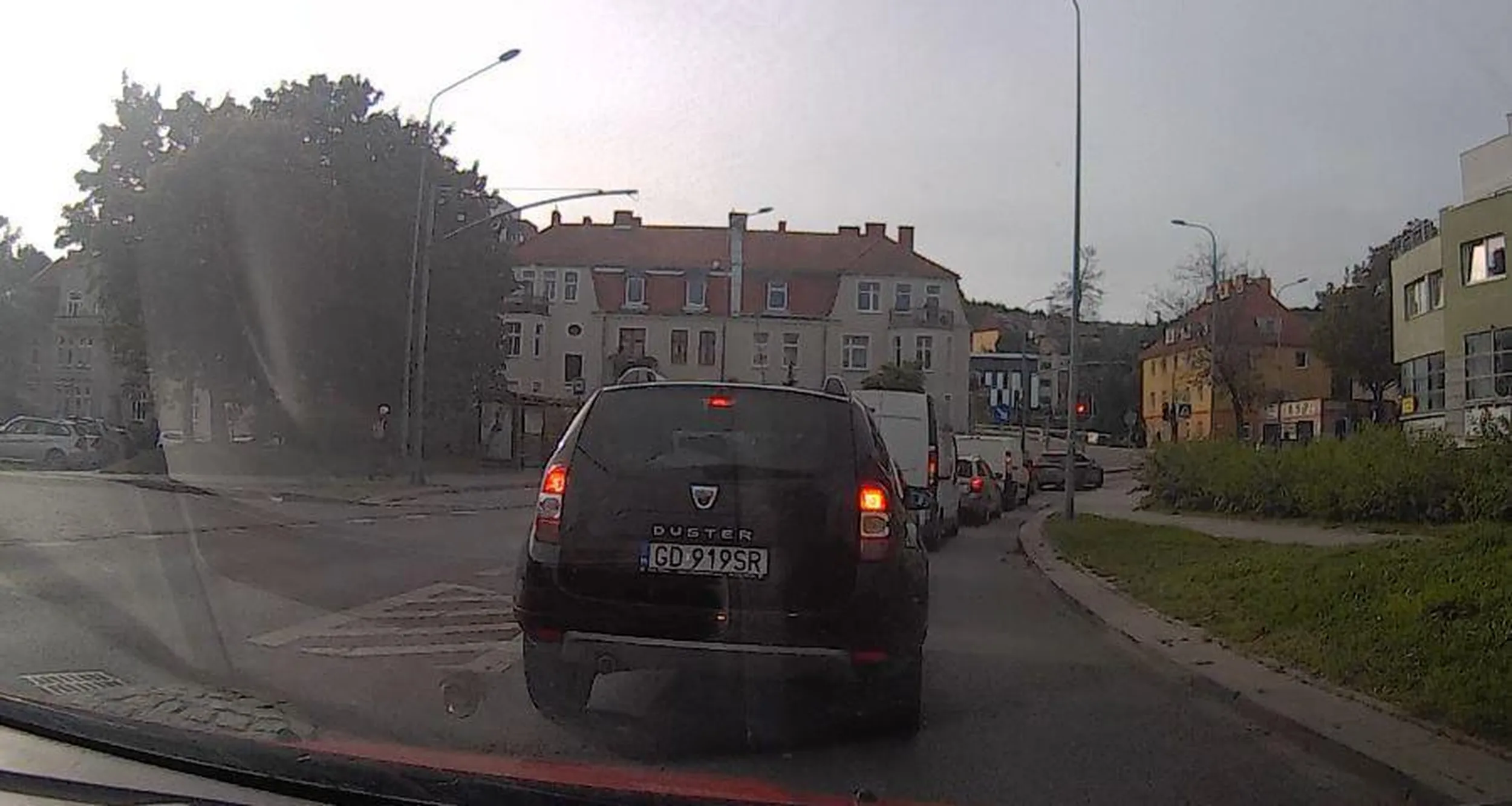 Czekanie na czerwonych światłach się znudziło. Wjazd samochodu Dacia Duster GD919SR na skrzyżowanie na czerwonym świetle (po około minucie czekania). Gdańsk - skrzyżowanie Chrzanowskiego i al. Żołnierzy Wyklętych.