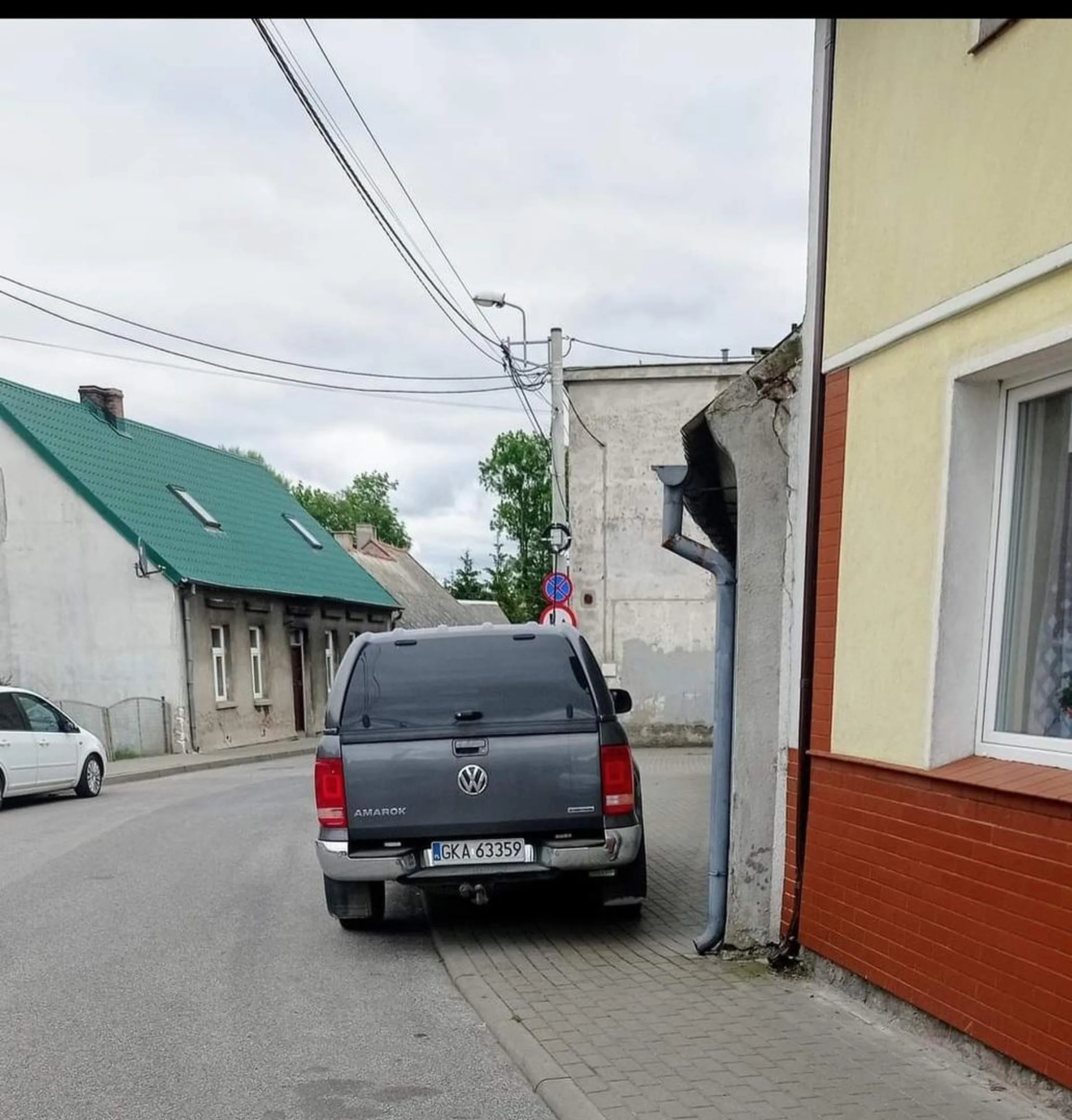 Pajac stoi na chodniku na całej szerokości.