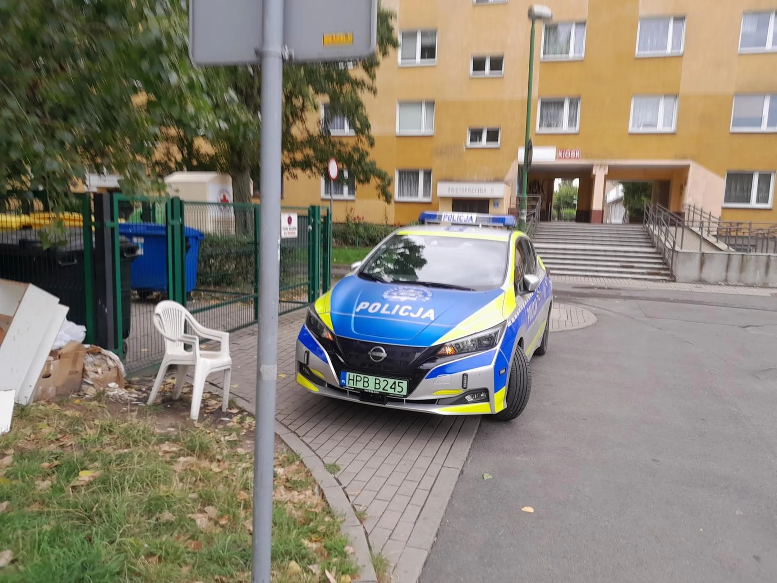 Radiowóz stoi na zakazie blokując śmietniki na osiedlu.