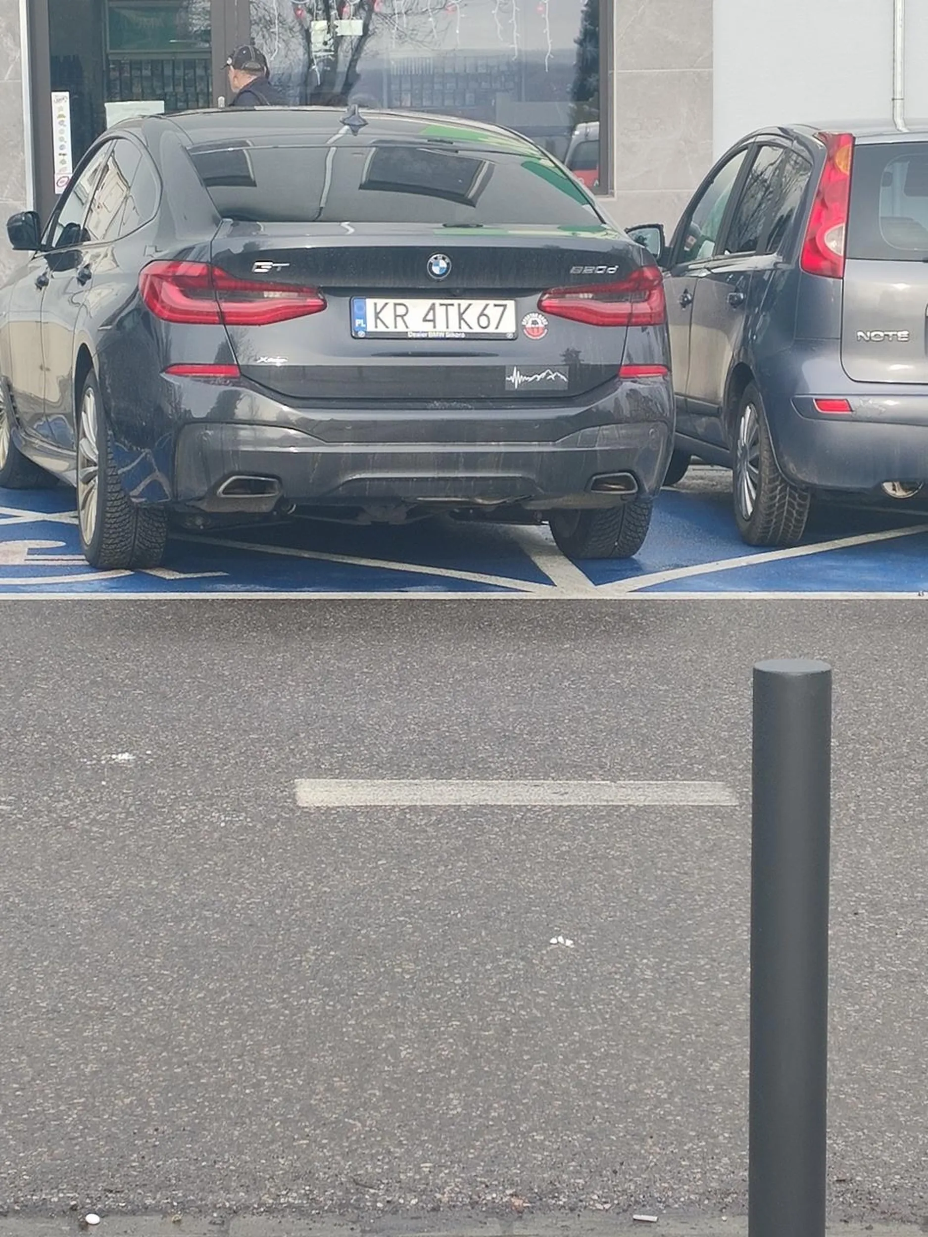 kobieta  stoi bez karty na miejscu dla inwalidów i wykracza na drugie miejsce też dla osób niepełnosprawnych