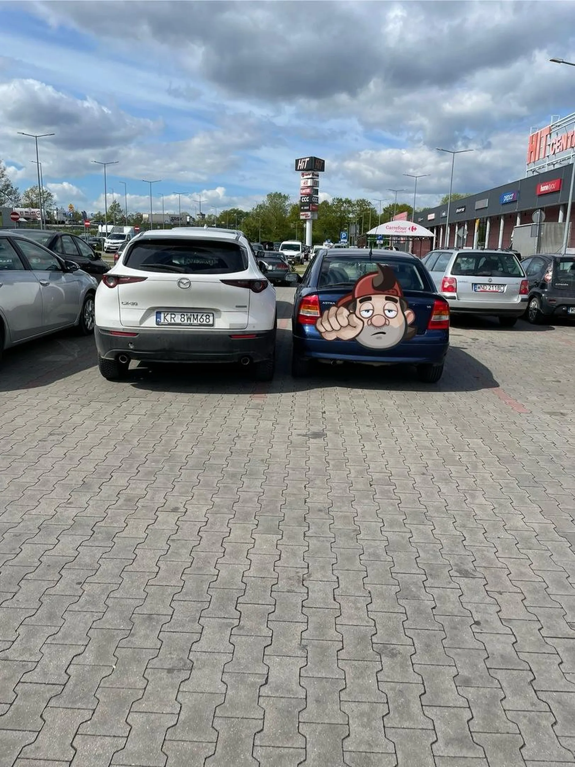 Kierowca mając do wyboru kilka miejsc parkingowych postanowił zaparkować prawie, że bokiem koło mnie, blokując mi wejście do samochodu (drzwi da się otworzyć na 10cm), z drugiej strony zostawiając co najmniej metr miejsca. Nie pozdrawiam i polecam zapisać się na jeszcze raz na kurs, skupiając się na nauce parkowania.