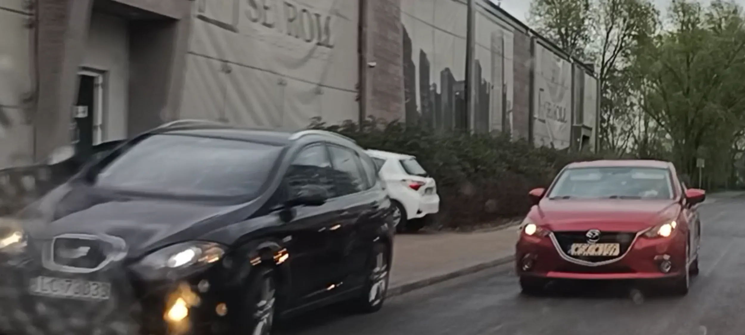 Czarny Seat utrudnia ruch i mogło dojść do zdarzenia czerwonego auta że moim. Seat stoi w miejscu zakazu zatrzymywania się i postoju