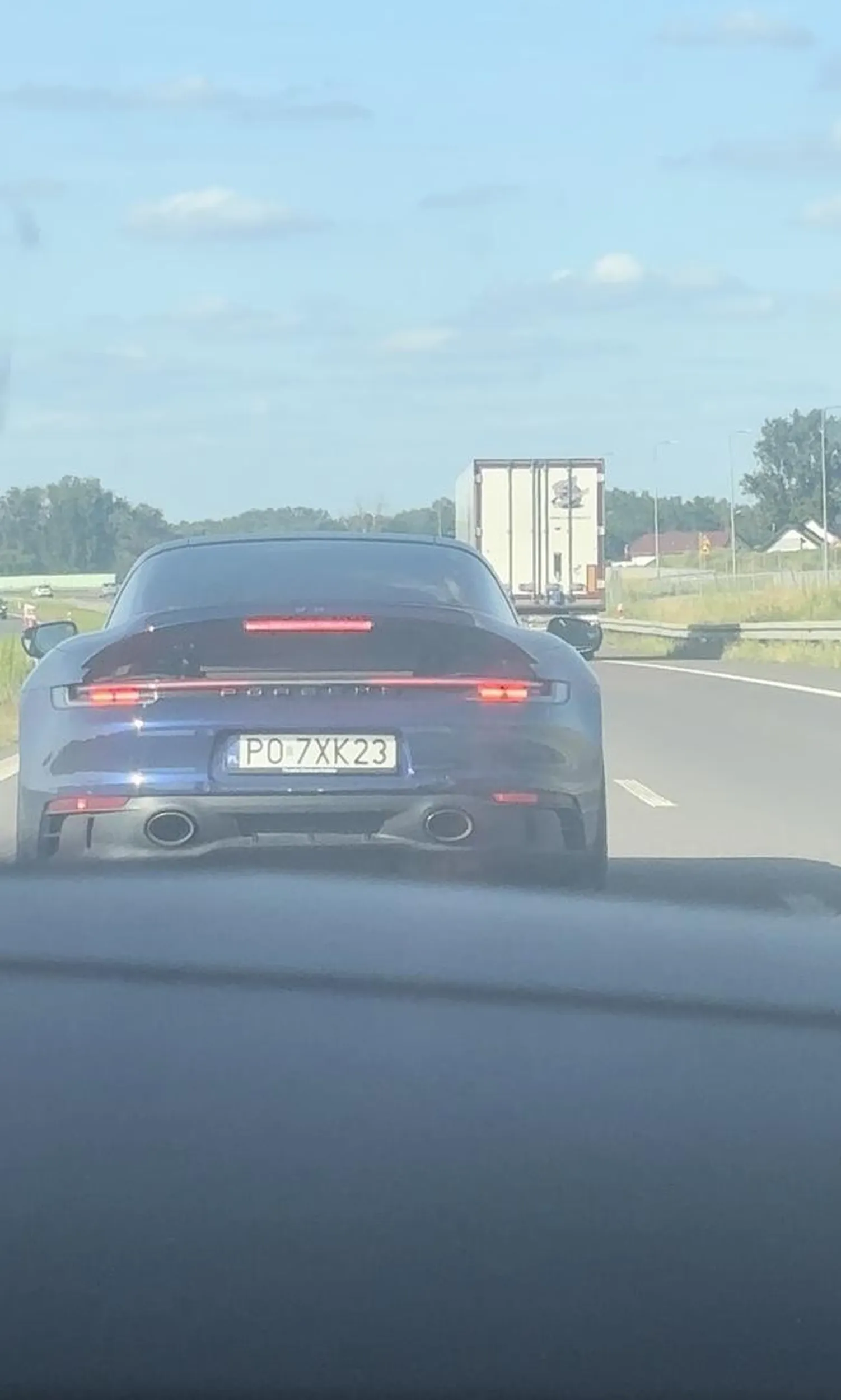 Młody blondyn w kręconych włosach na autostradzie przy prędkości 230 km/h najpierw siedzi na zderzaku i miga długimi światłami, aby następnie po wyprzedzeniu zahamować z całej siły, praktycznie wywołując wypadek a wszystko po to by zaimponować koleżance na fotelu pasażera. Jeździj tak dalej w tym niebieskim porsche.