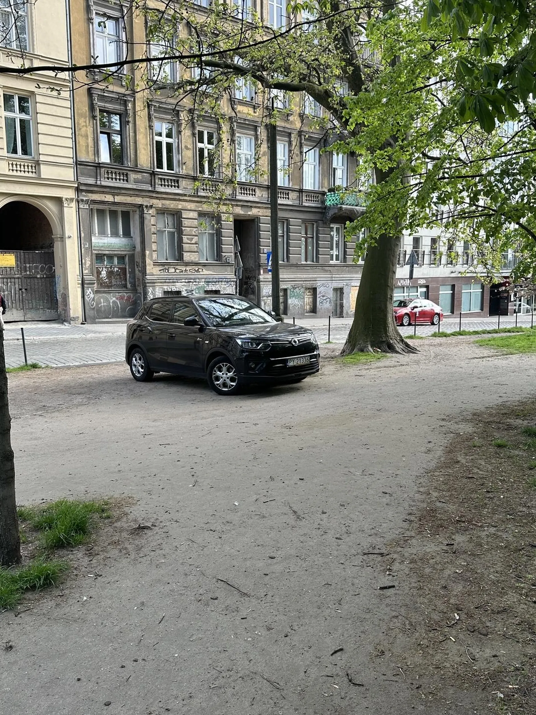 Kierowca jeździ po chodniku i parkuje nielegalnie rozjeżdżając teren zielony.