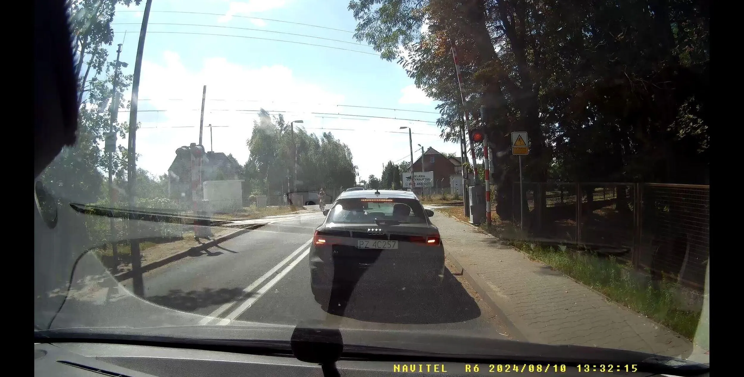 Kierowca wyprzedza rowery na przejeździe kolejowym, zmuszając pojazd naprzeciwko do zatrzymania się w miejscu, aby nie doprowadzić do kolizji! Srebrny Range Rover - omijać.