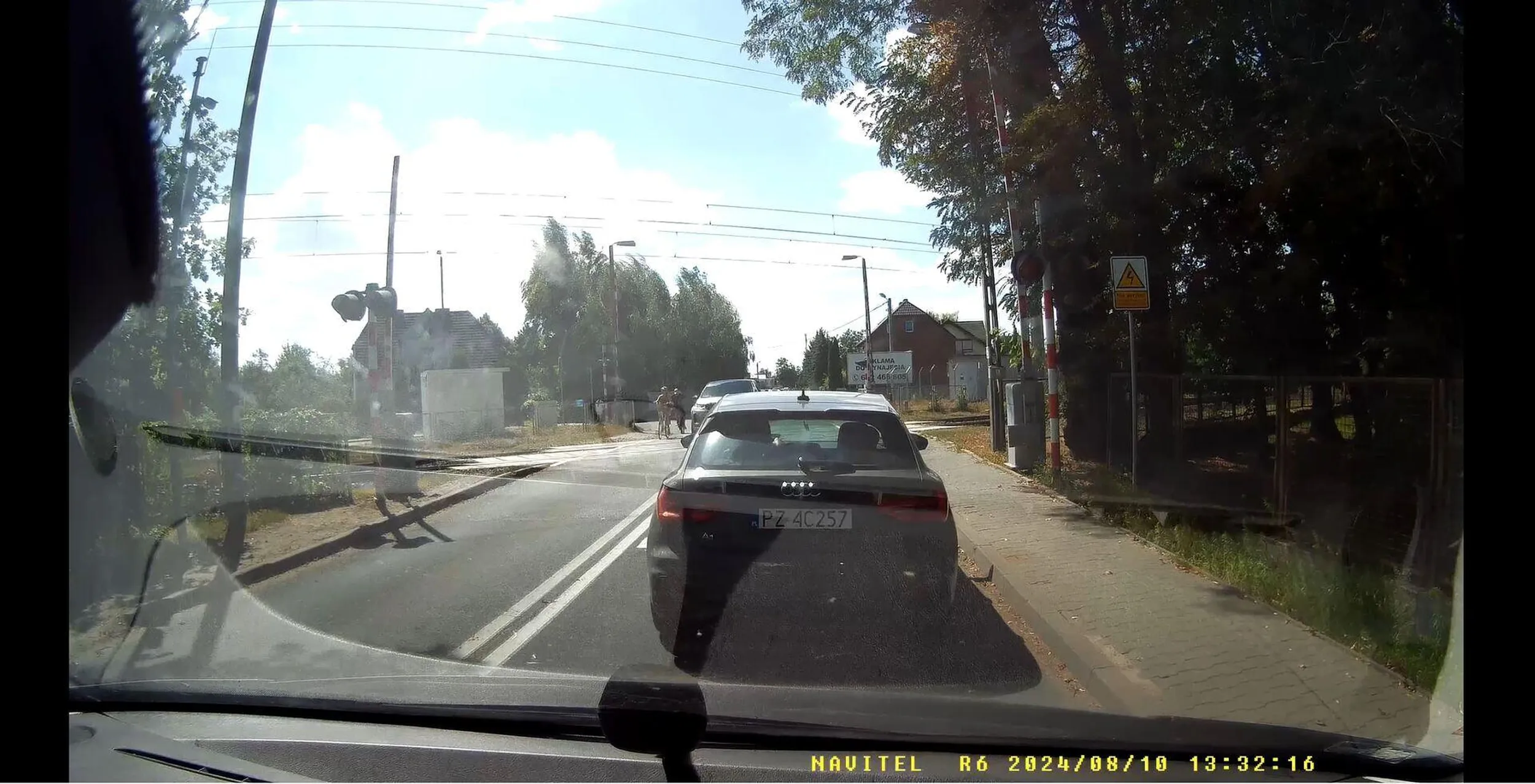 Kierowca wyprzedza rowery na przejeździe kolejowym, zmuszając pojazd naprzeciwko do zatrzymania się w miejscu, aby nie doprowadzić do kolizji! Srebrny Range Rover - omijać.