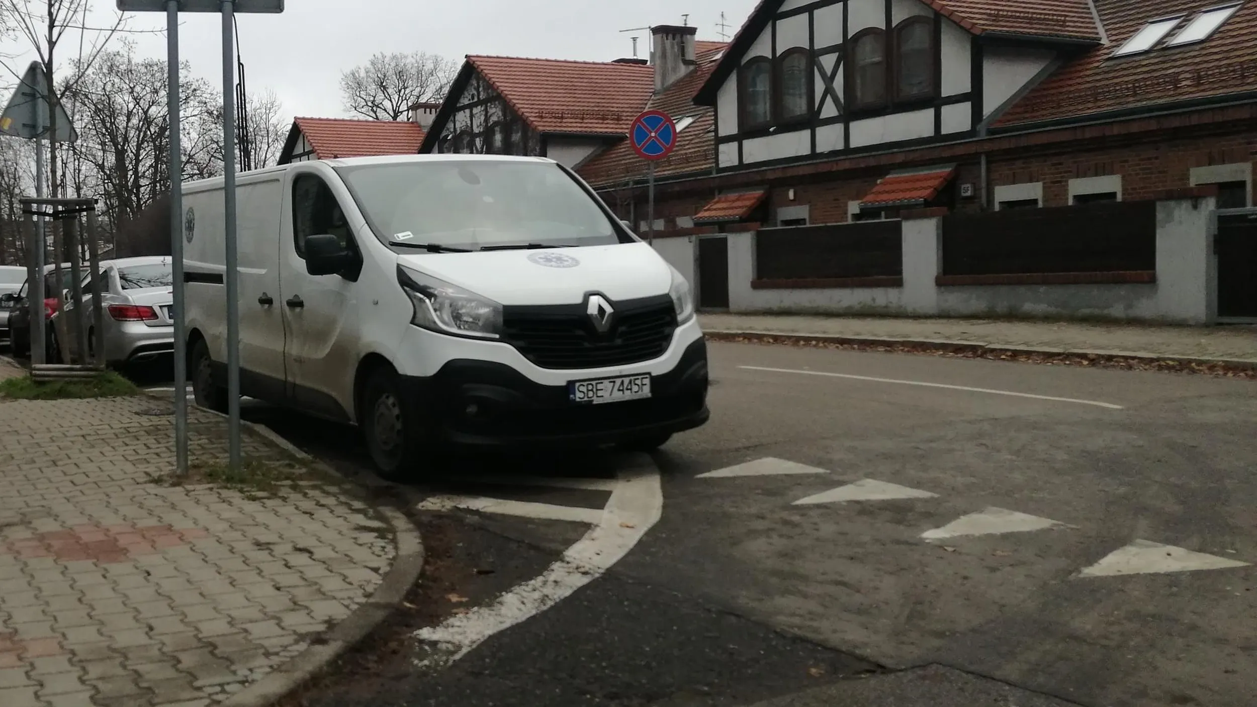 Menda parkuje na powierzchni wyłączonej z ruchu i w obrębie skrzyżowania. Ogranicza widoczność.