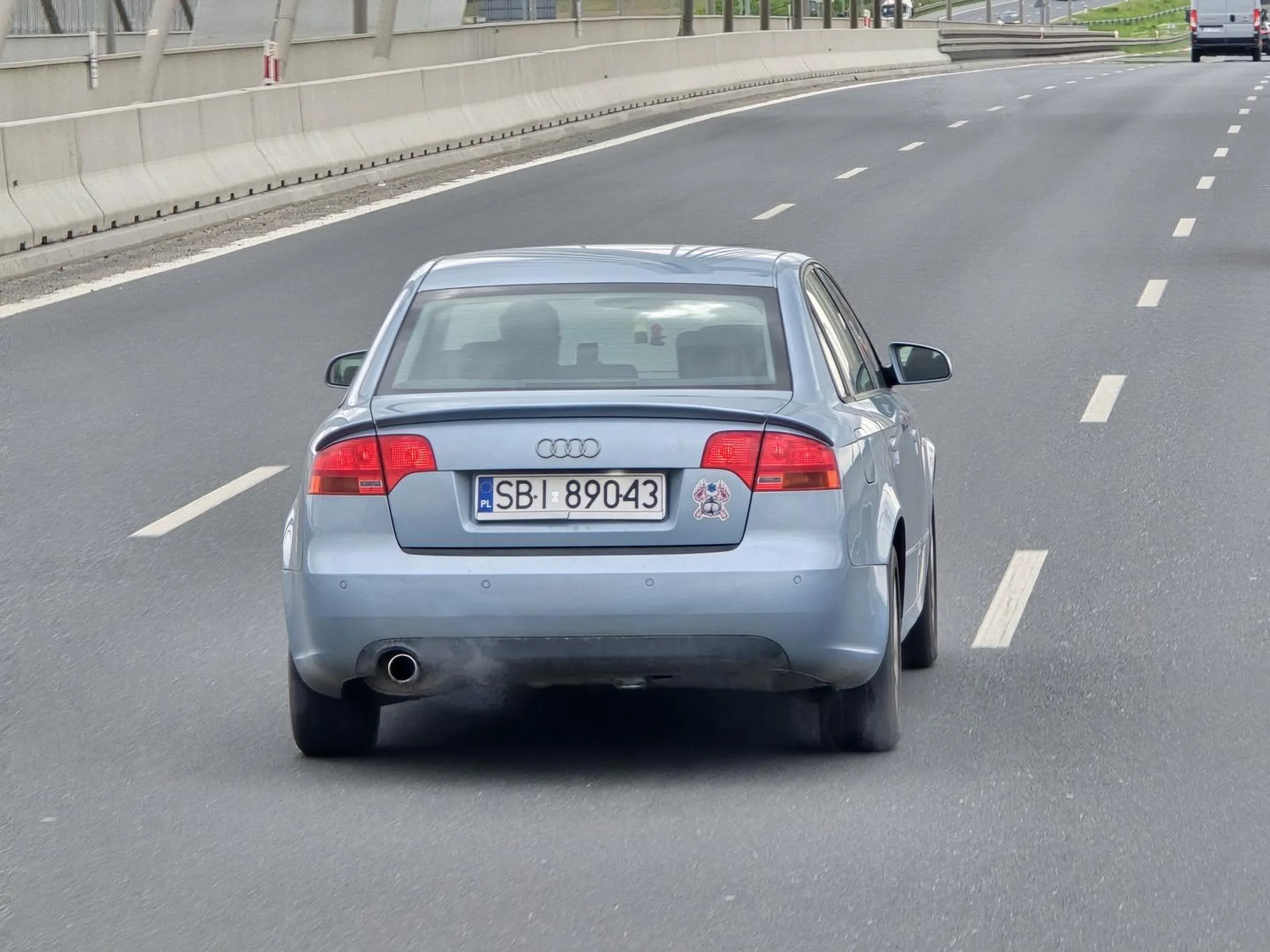 Niepoważny kierowca, stwarza poważne zagrożenie na drodze bawiąc się komórką podczas jazdy.