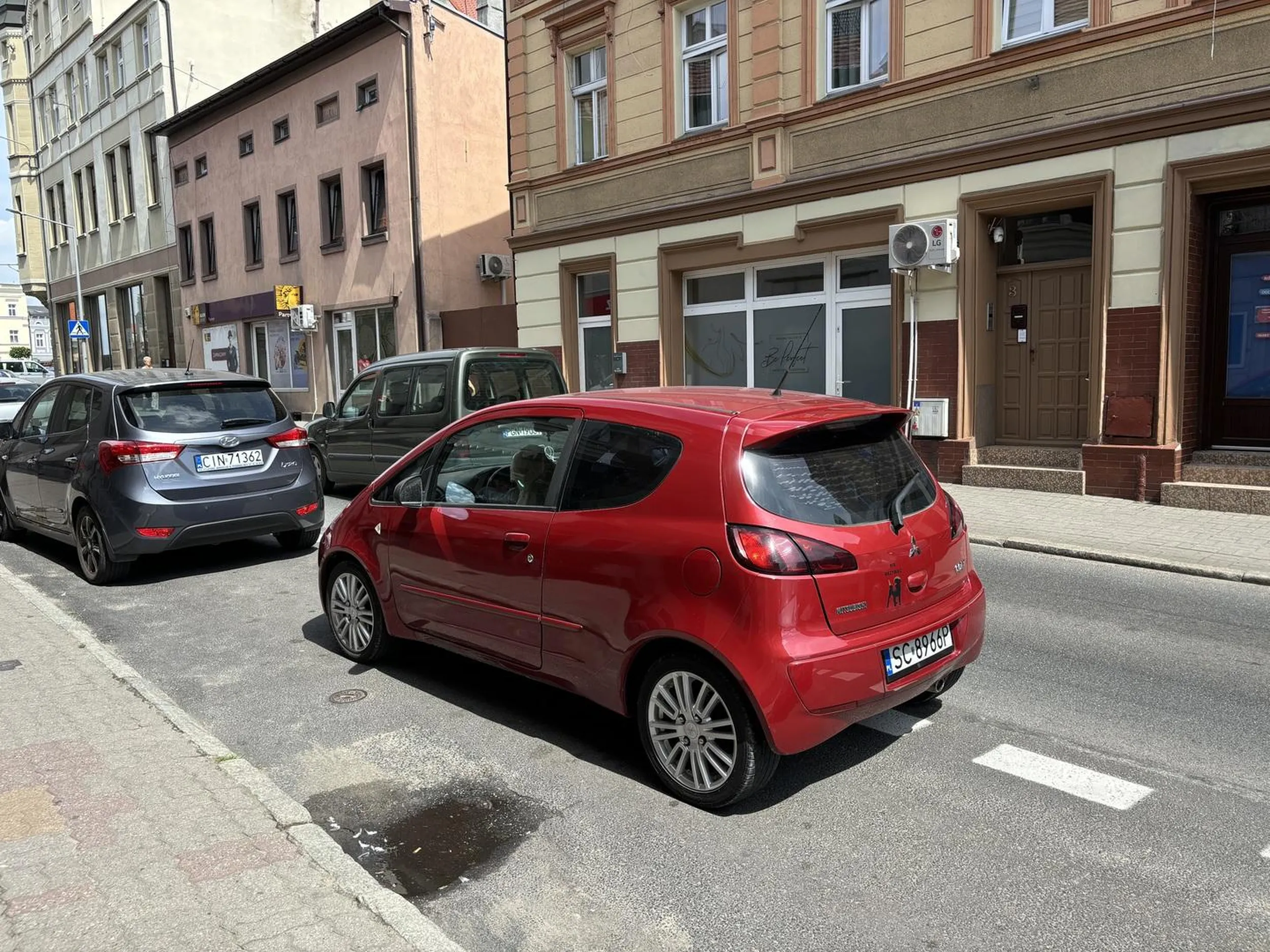 Gratulacje dla kierowcy umiejętności parkowania auta . Połowa samochodu stoi na ulicy a ten zadowolony drapie się bo brzuchu .