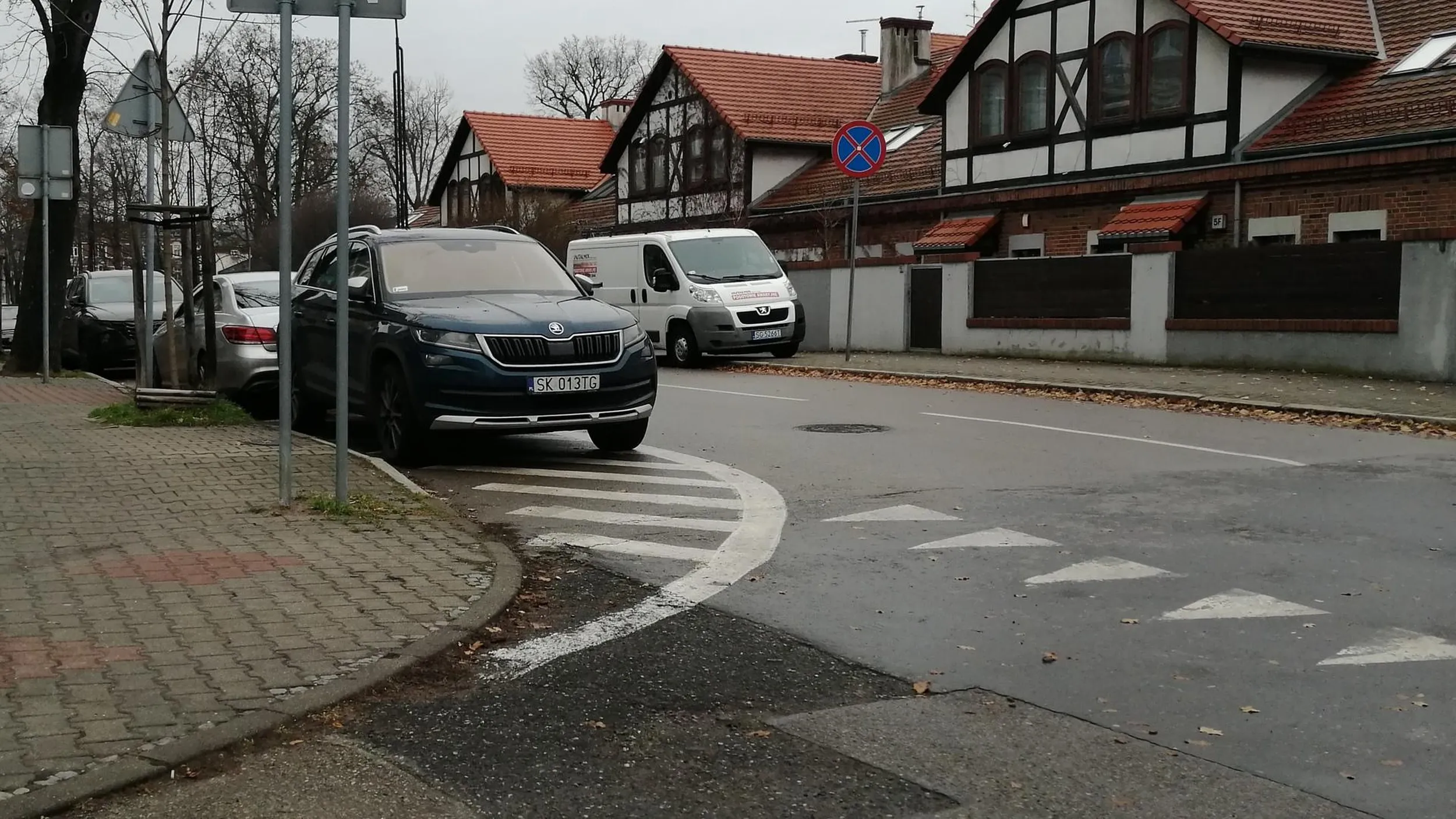 Menda parkuje na powierzchni wyłączonej z ruchu i w obrębie skrzyżowania. Zasłania widoczność.