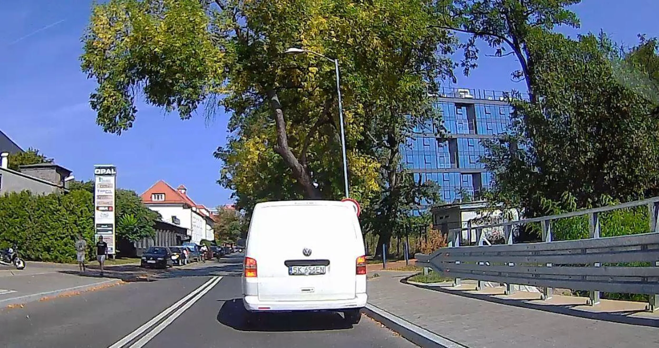 Chłopiec parkuje na moście i zajmuje się grzebaniem w nosie.