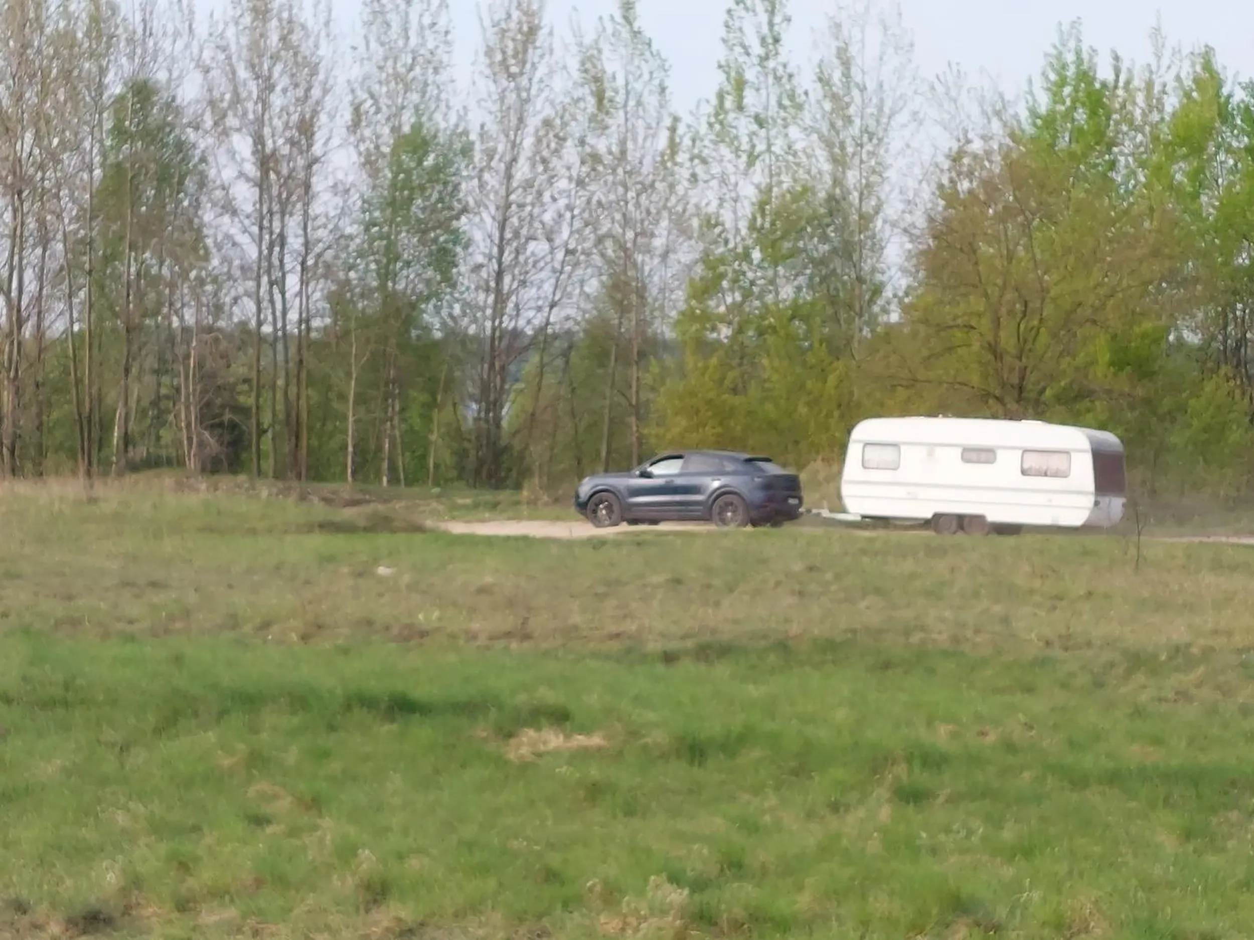 Koleś w swoim Porsche nielegalnie dostarcza zdezelowaną przyczepę kampingową 13.04.2024 na plaże Pogorii IV zaśmiecając okolice i łamiąc zasady. Uważać na dziada.