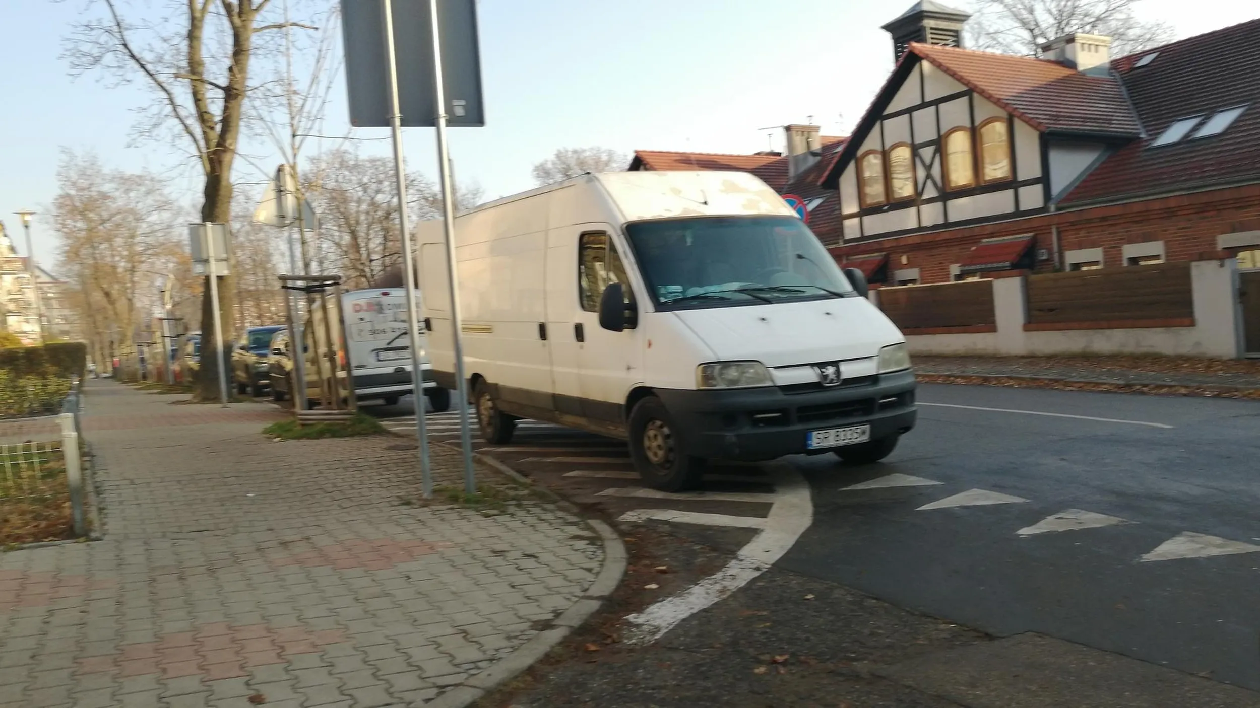 Menda parkuje na powierzchni wyłączonej z ruchu i w obrębie skrzyżowania. Zasłania widoczność.
