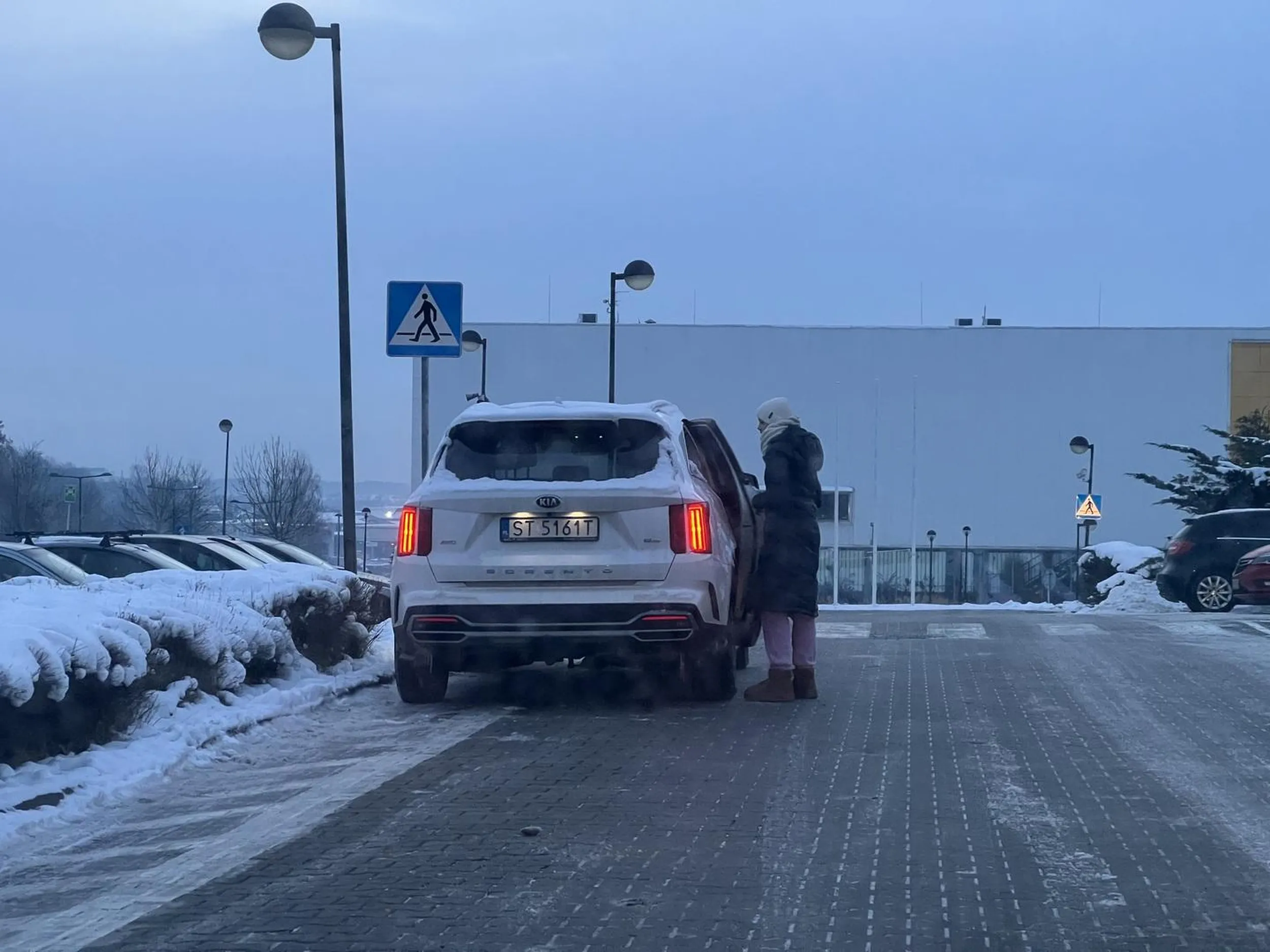 Kobieta w białej kiwi notorycznie parkuje na zakazie, strefie wyłączonej z ruchu i przed przejściem dla pieszych, do tego urządza sobie pogaduchy na środku drogi