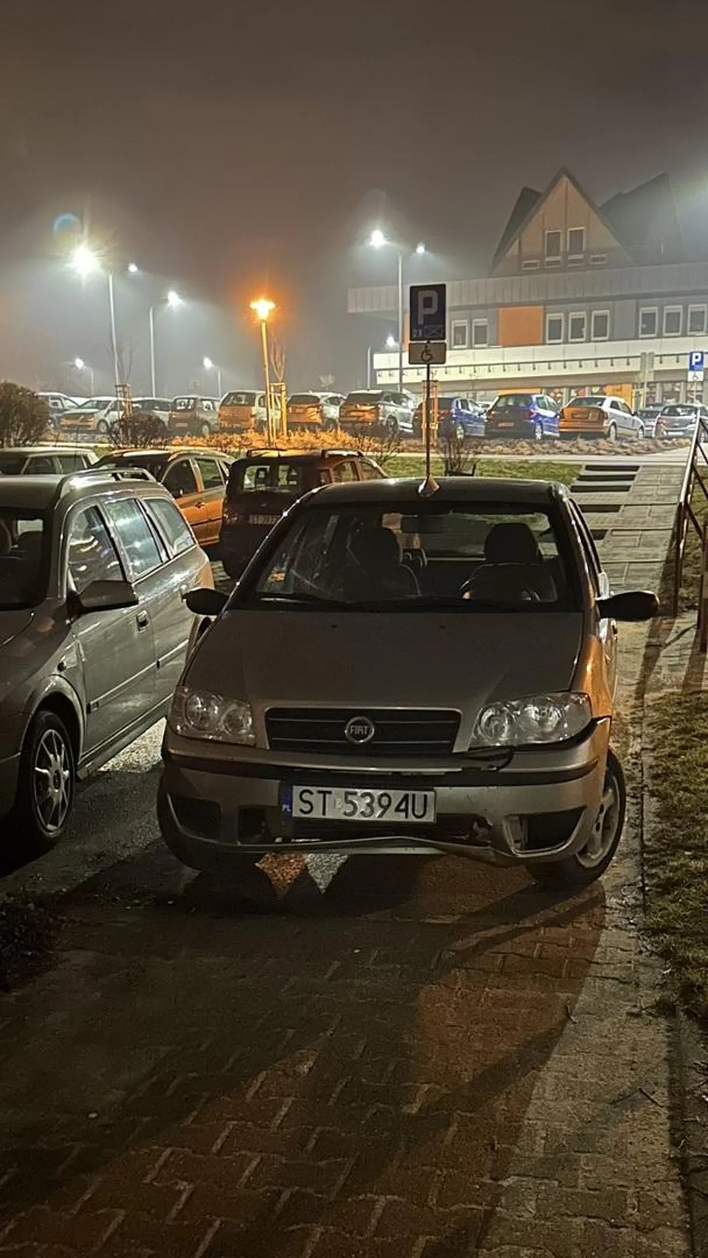 Stoi na osiedlowym przejściu dla pieszych. Dalej podjazd dla, chociażby, wózków dziecięcych. Miło :)