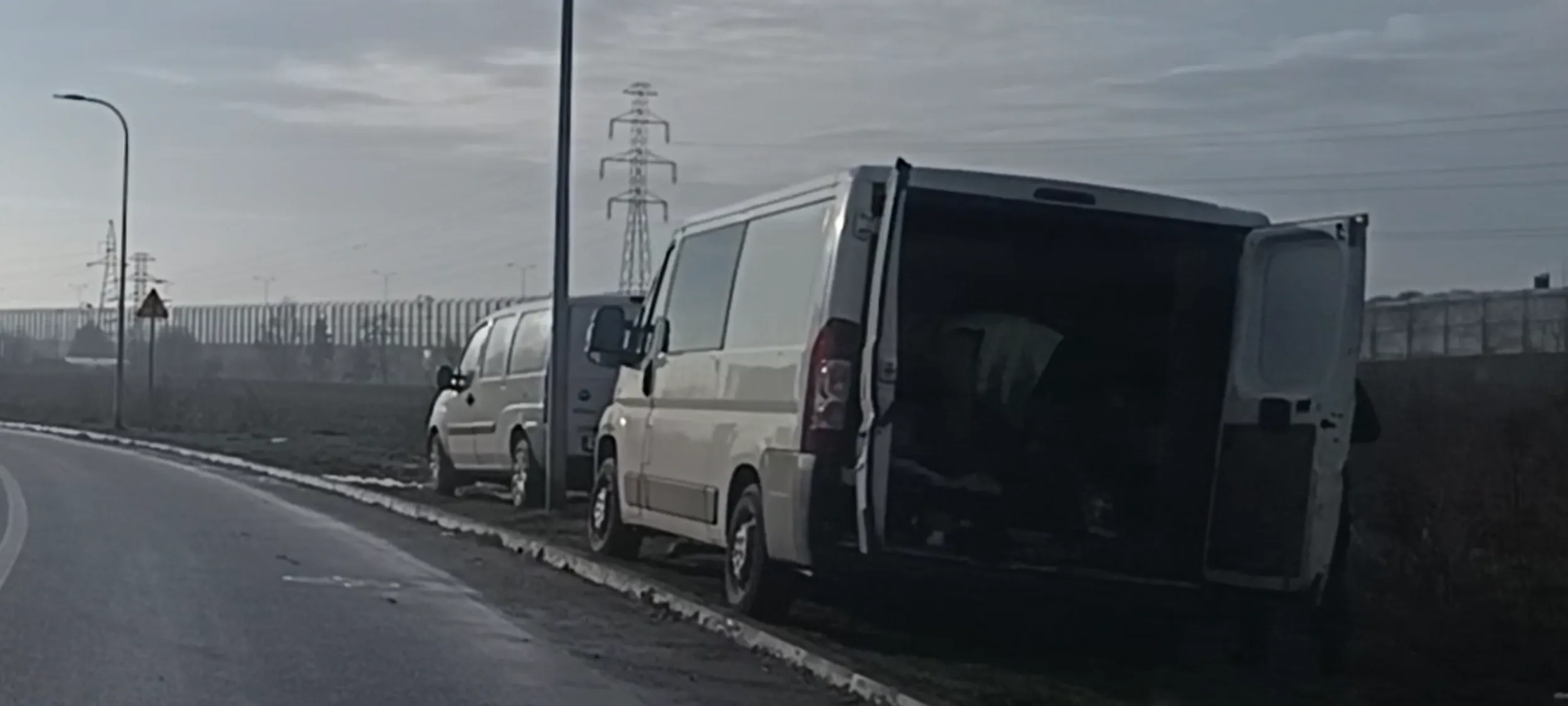 Auto stoi w błocie po zniszczonym trawniku przy ulicy gdzie jest zakaz zatrzymywania się i postoju