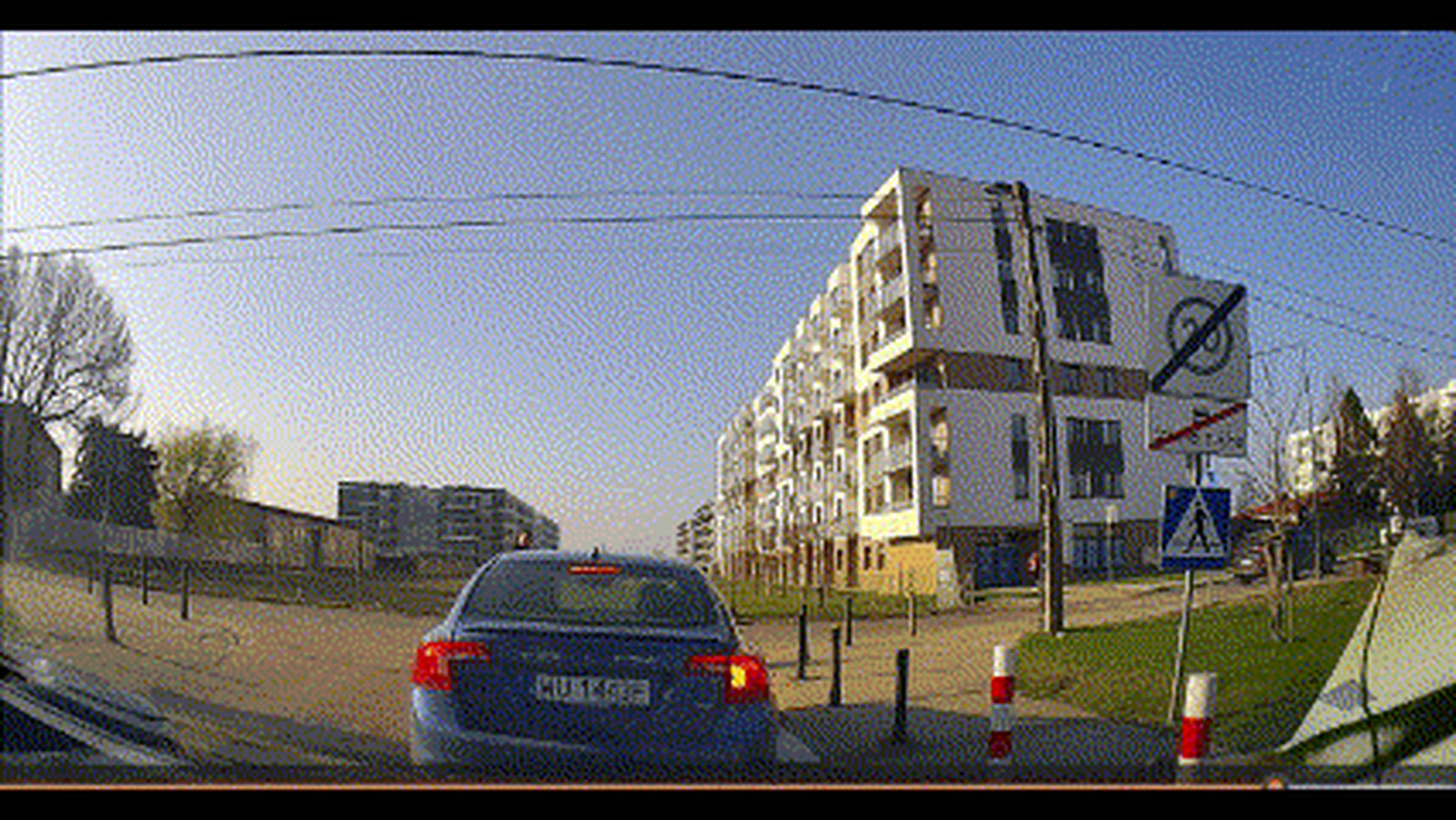 Wyjazd z parkingu osiedlowego. Opel Corsa, nie chcąc czekać w kolejce na wyjazd, wyprzedza z lewej i zajeżdża drogę, aby być pierwszy na wyjeździe.