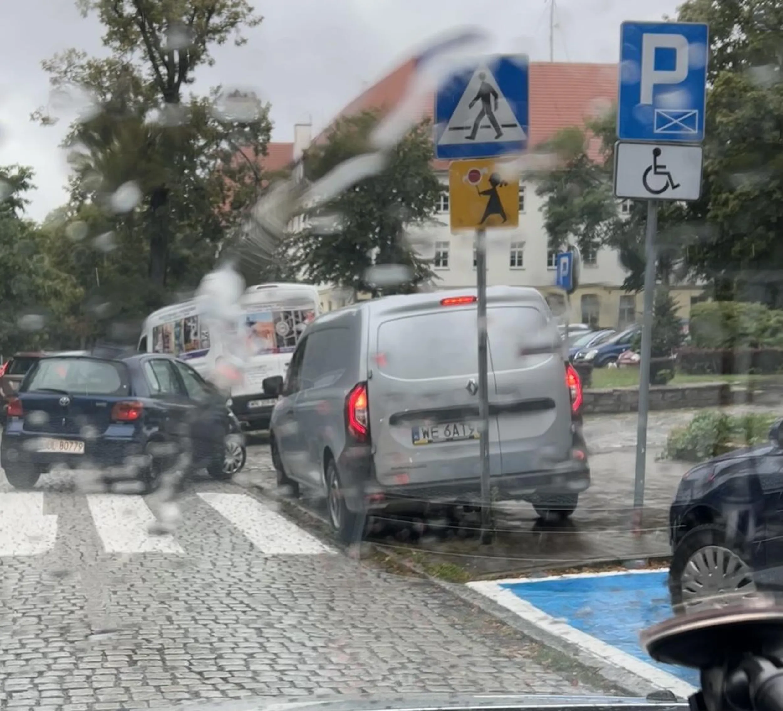 Dzieci w deszczu nie mają jak przejść po szkole przez pasy