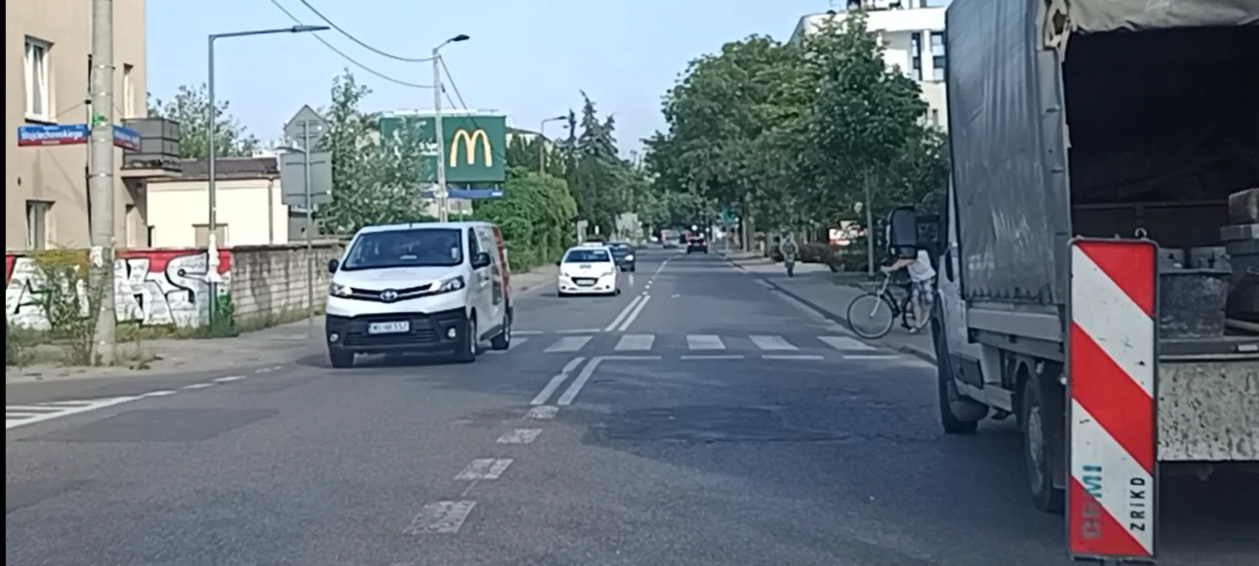 Bandyta drogowy przejeżdża przed nosem pieszego z rowerem na przejściu dla pieszych