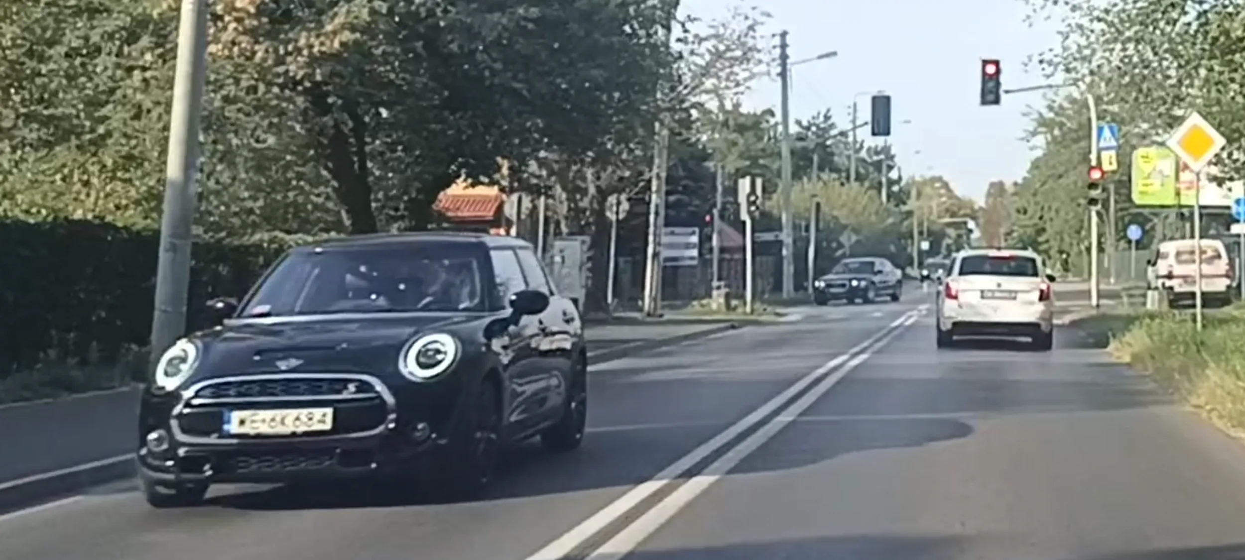 Bandyta drogowy przejeżdża przez skrzyżowanie na czerwonym sygnalizatorze świetlnym