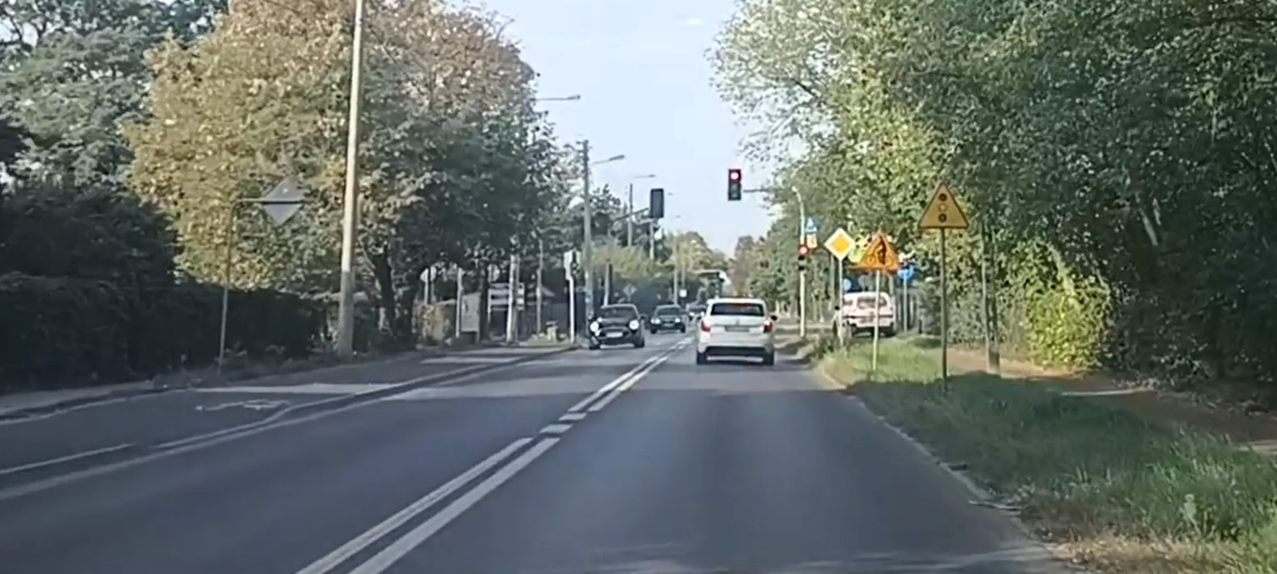 Bandyta drogowy przejeżdża przez skrzyżowanie na czerwonym sygnalizatorze świetlnym