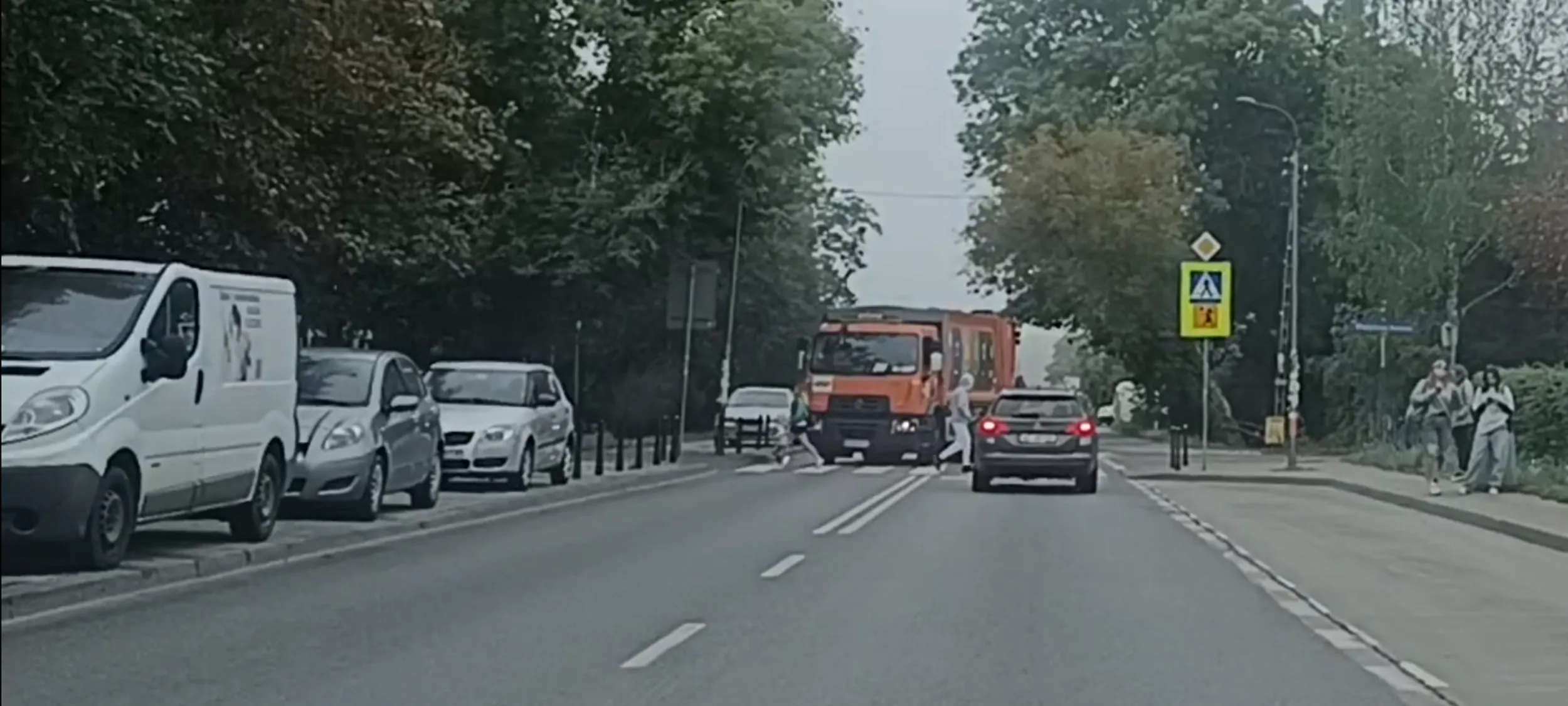 Bandyta drogowy przejeżdża przez przejście dla pieszych i nie ustąpił pierwszeństwa matce z dzieckiem stojącej przy jezdni