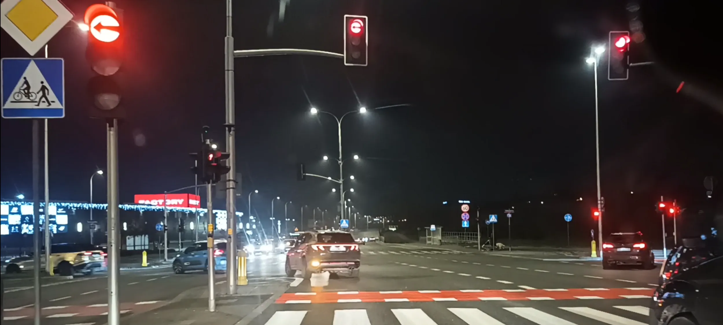 Bandzior drogowy przejeżdża przez skrzyżowanie na czerwonym świetle