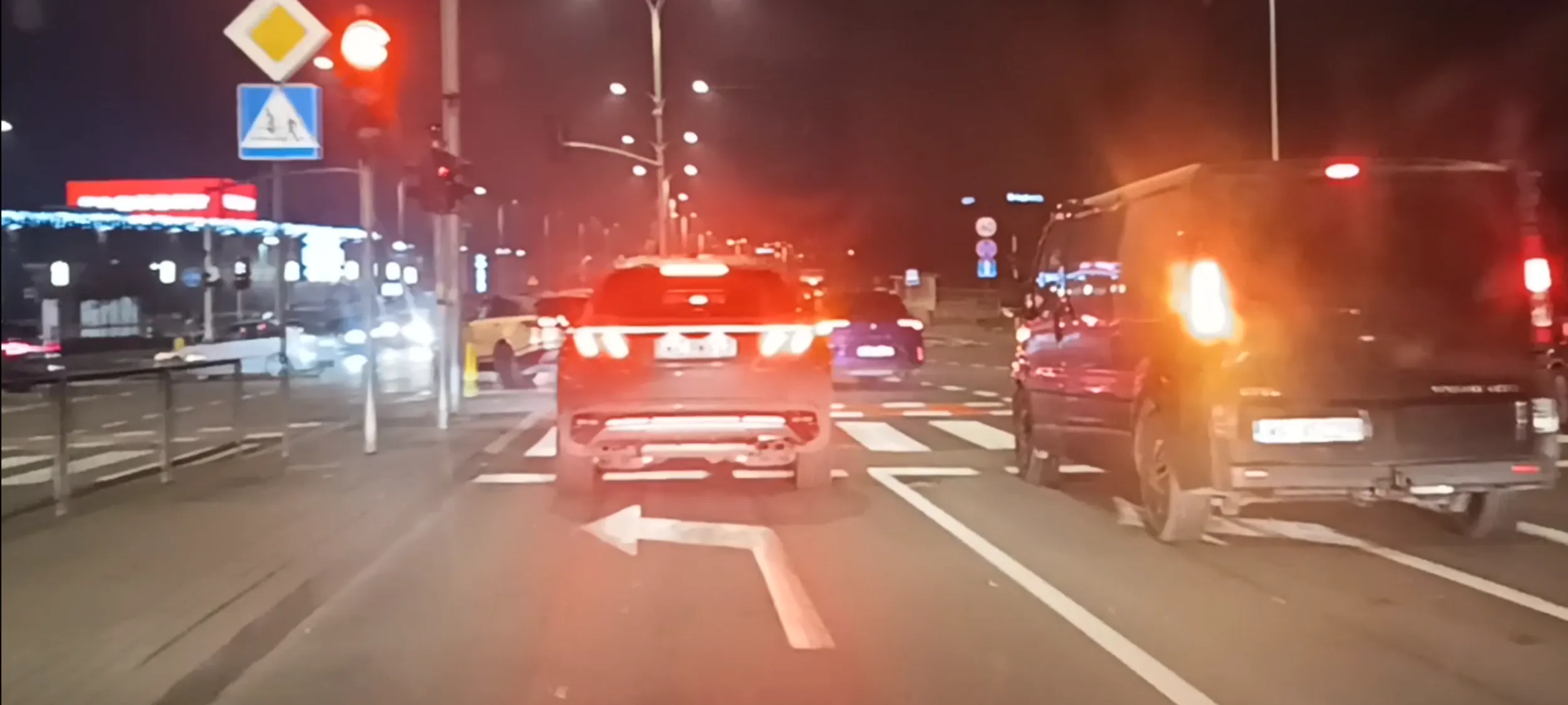 Bandzior drogowy przejeżdża przez skrzyżowanie na czerwonym świetle