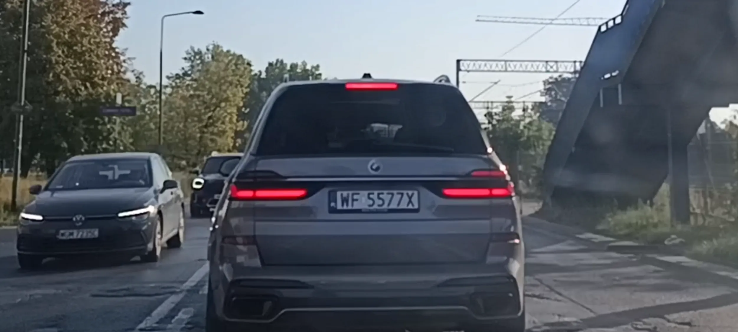 Kierujący tłusty dziad pisze SMSy  na telefonie komórkowym w czasie jazdy samochodem