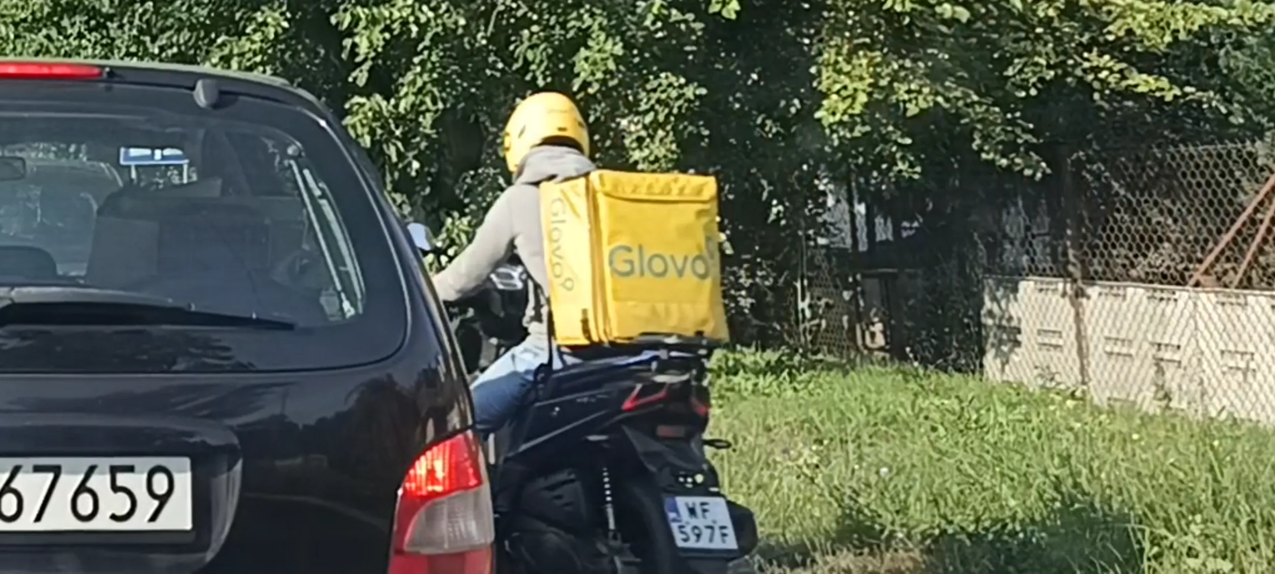 Bandyta drogowy i muzułmański z Bangladeszu na skuterze wyprzedza poboczem z prawej strony.