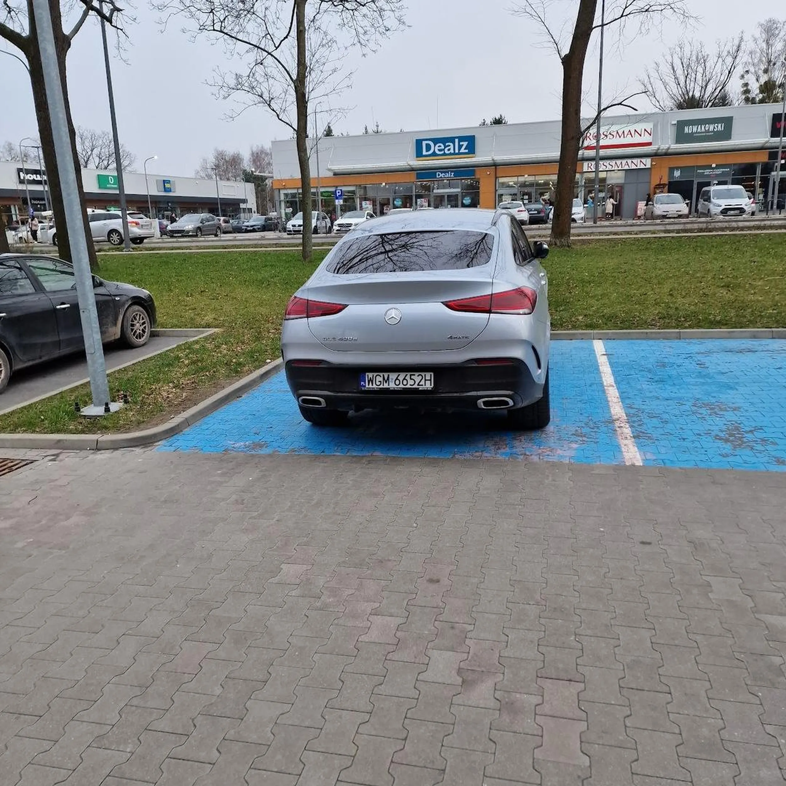 Elegancka Pani z nowiutkiego Mercedesa SUV idzie na zakupy, zapomniała tylko, że nie wzięła rodziny, sądząc po tym, że stanęła na miejscu dla rodzin. Pewnie Pani Businesswoman dużo ma na głowie i mogła zapomnieć, że rodzina czeka w garażu ;) No i to na pewno jej, a nie męża czy szefa :D Mieć takie auto, a nie mieć rozumu, godności, ani umiejętności jazdy ;] To nie zazdrość (bo mam podobne), to pogarda.