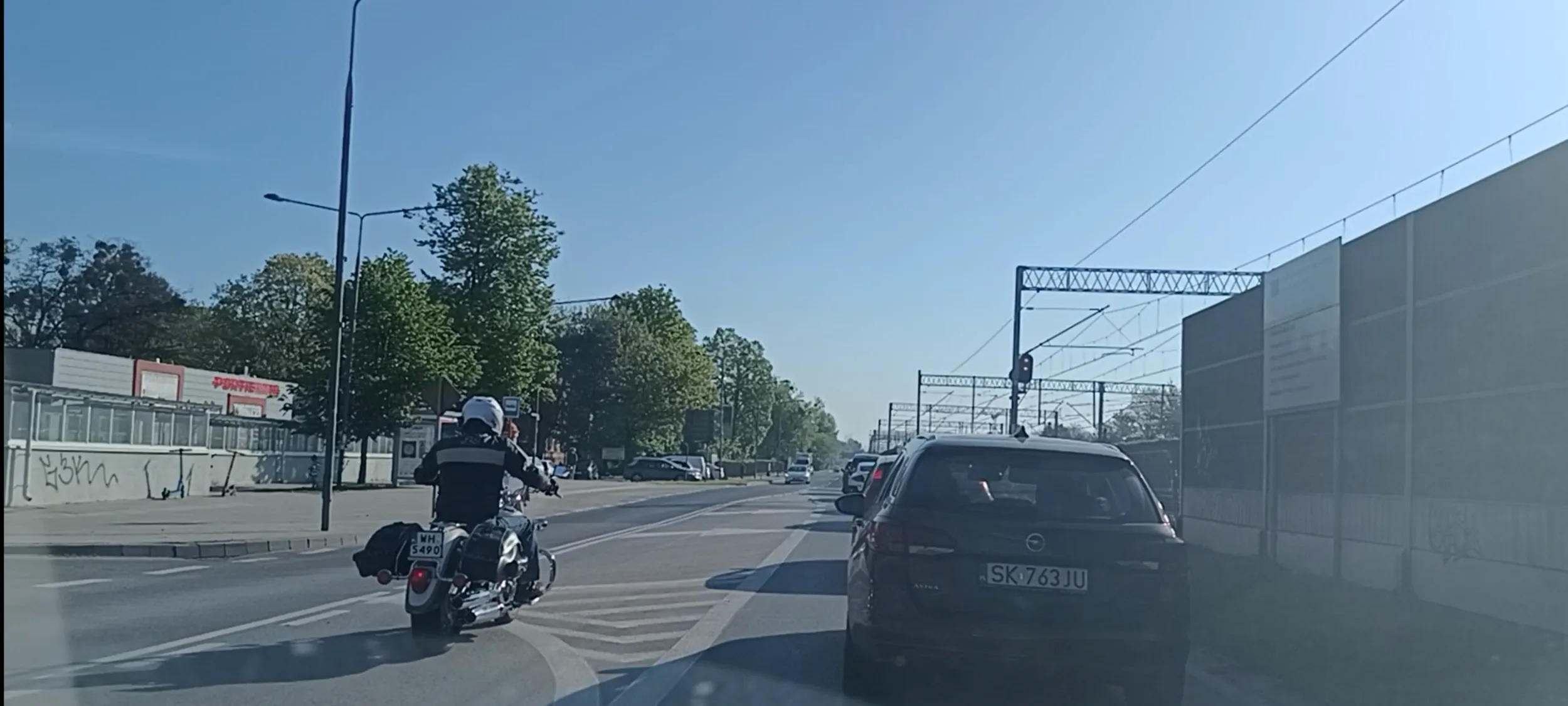 Bandyta drogowy na motocyklu wyprzedza na przejściu dla pieszych i potem na podwójnej linii ciągłej, jeździe prosto z pasa do skrętu w lewo i przekracza prędkość. Bandzior.