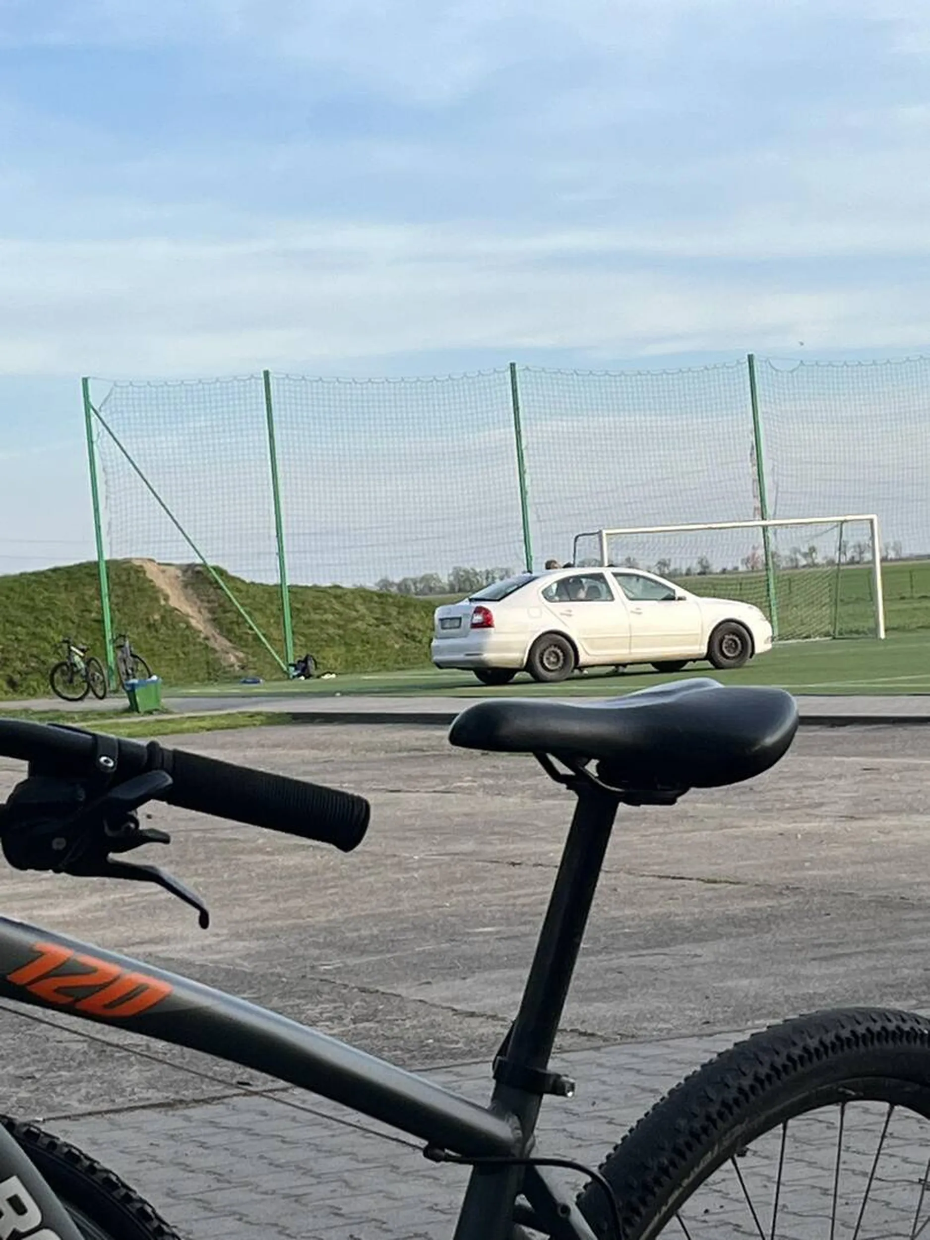 Nie pozdrawiam kierowca wjeżdża samochodem na boisko wykonane z sztucznej murawy.