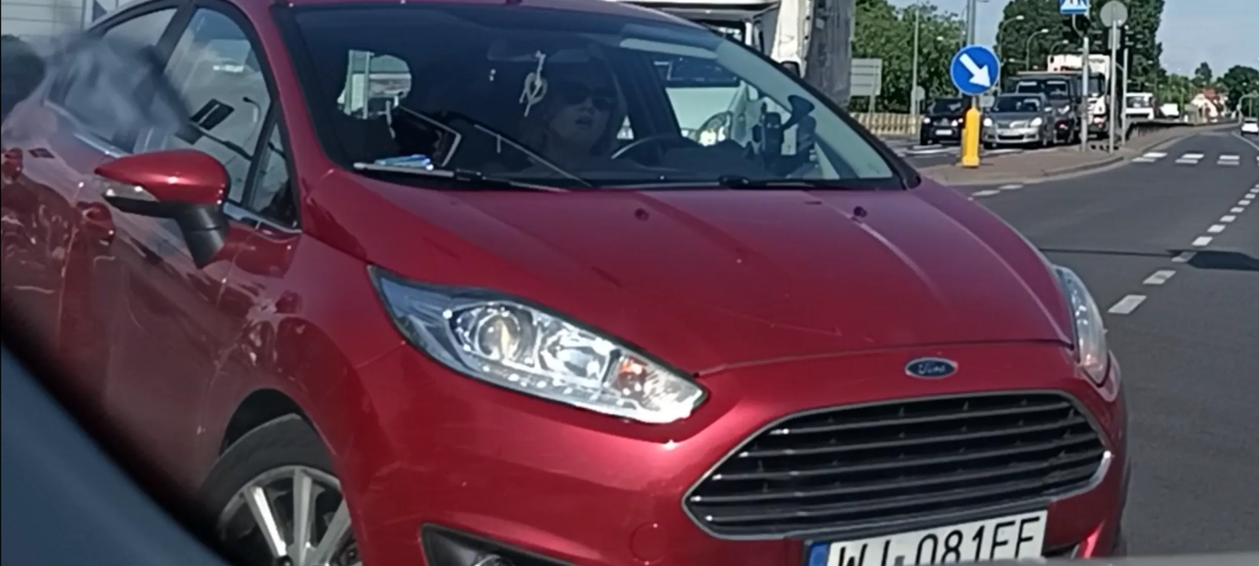 Babszczur wbija się na skrzyżowanie na czerwonym sygnalizatorze świetlnym do skrętu i tamuje ruch aut jadących prosto na zielonym  świetle. Do tego babszczur, po tym jak został zablokowany, pokazuje palca fakulca i drze ryja opluwając szybę.