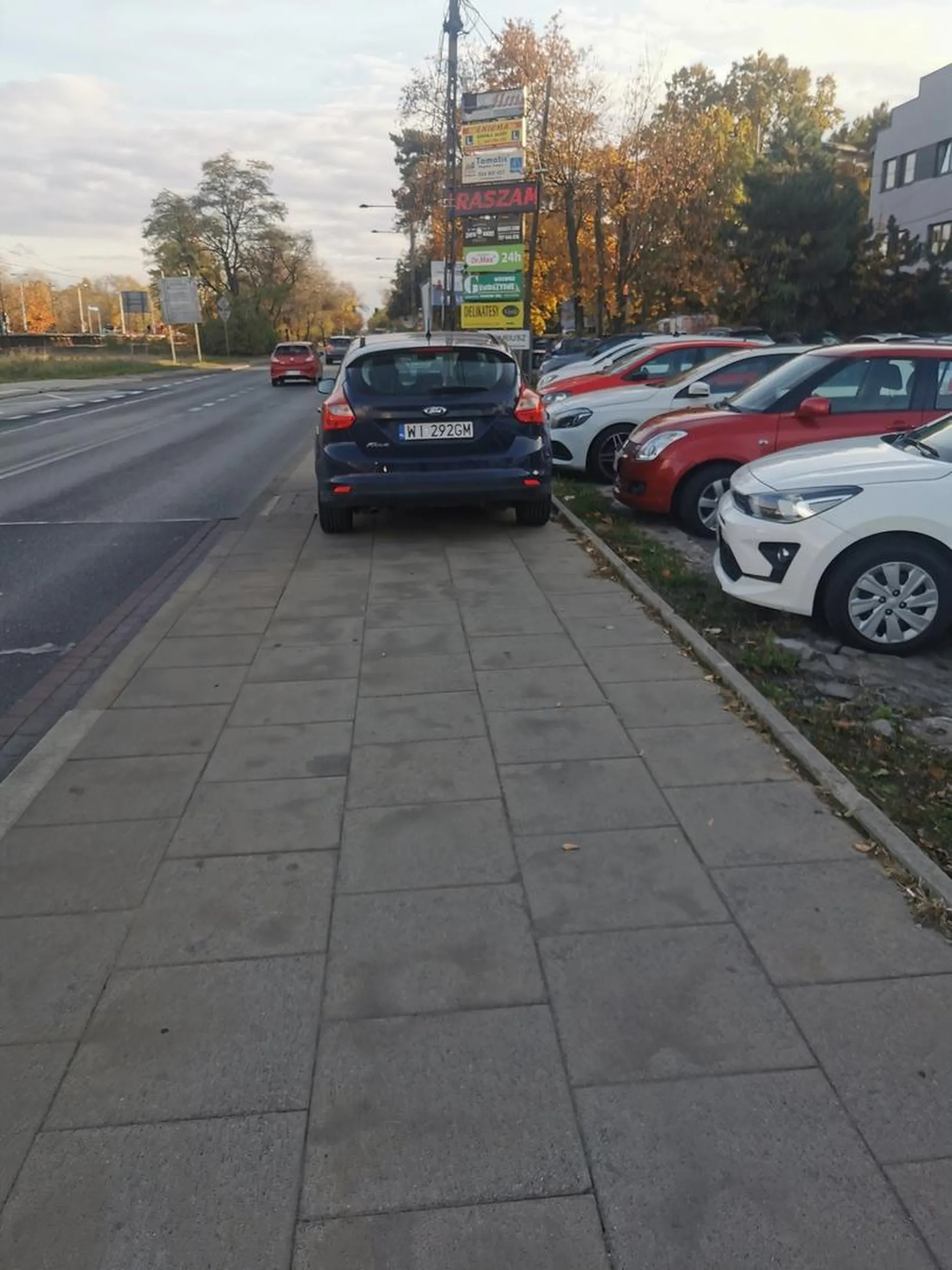 Parkowanie centralnie na chodniku. Obok ruchliwa droga, a osoba na wózku, czy matka z dzieckiem musiałaby na nią wejść żeby ominąć tego buca