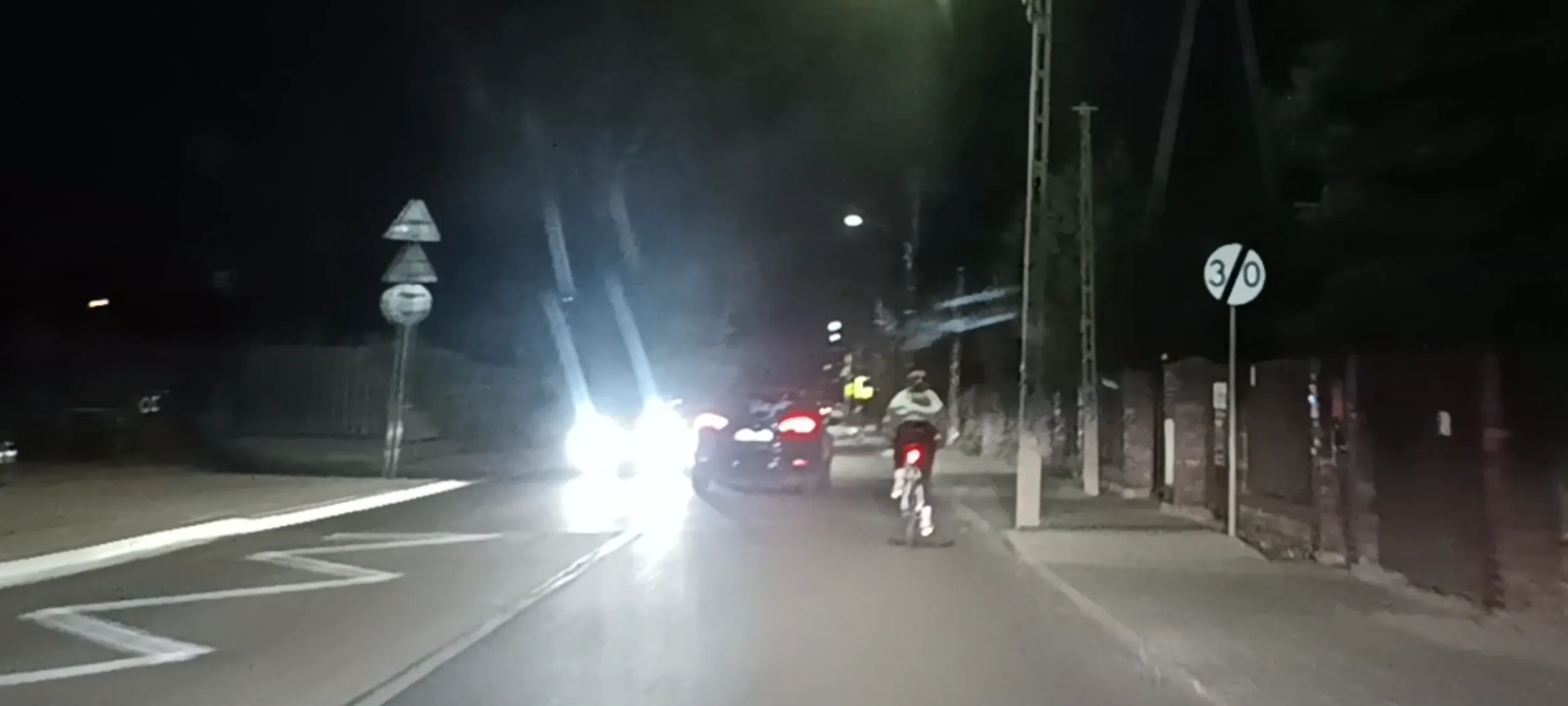 Bandyta drogowy wyprzedza rowerzystę wprost na nadjeżdżający samochód zmuszając go do zatrzymania się.